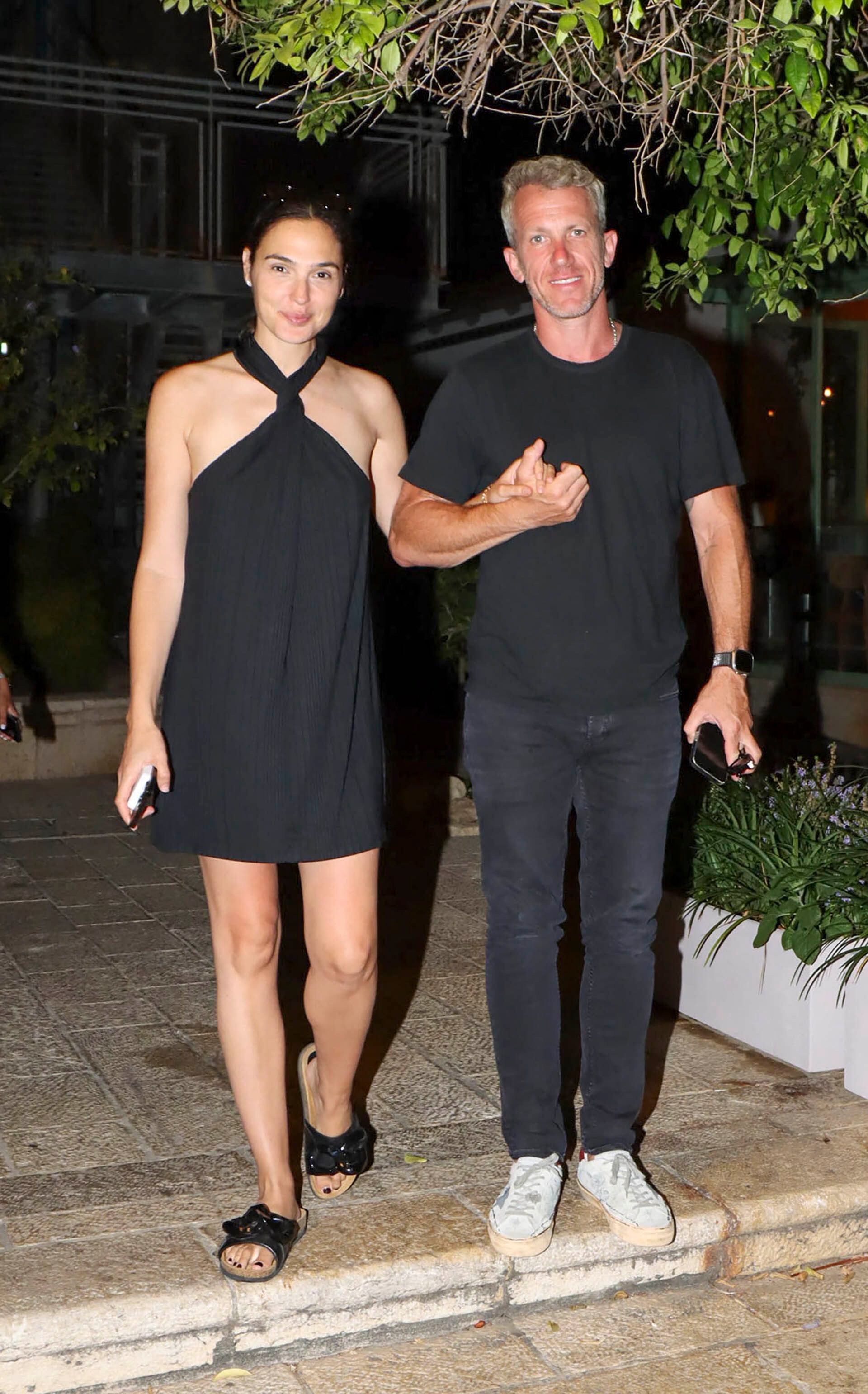 Noche romántica. Gal Gadot fue fotografiada cuando llegaba a un restaurante a comer con su marido durante en Tel Aviv, Israel. Ambos combinaron su look eligiendo el color negro: ella con un vestido y sandalias, y él llevó una remera y pantalón de jean