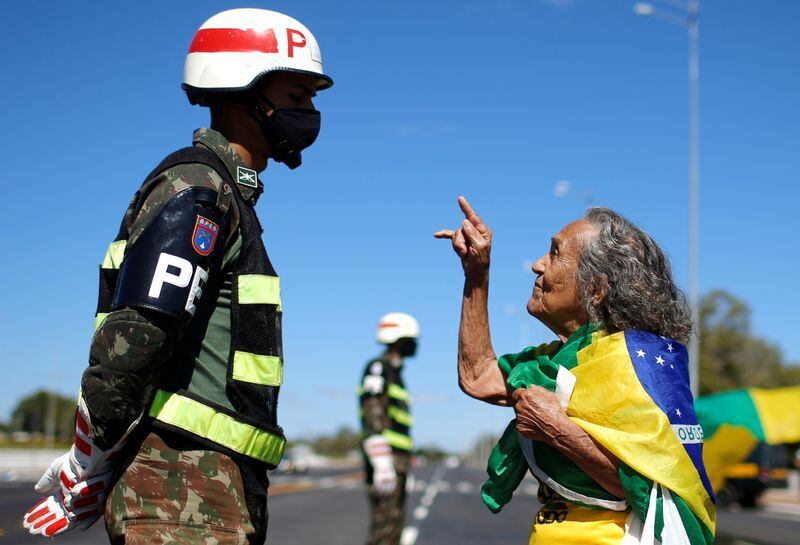 Una partidaria del presidente de Brasil, Jair Bolsonaro, gesticula frente a un soldado brasileño durante una protesta contra el Supremo Tribunal Federal, frente al cuartel general del Ejército en Brasilia, Brasil. 14 de junio, 2020. REUTERS/Adriano Machado