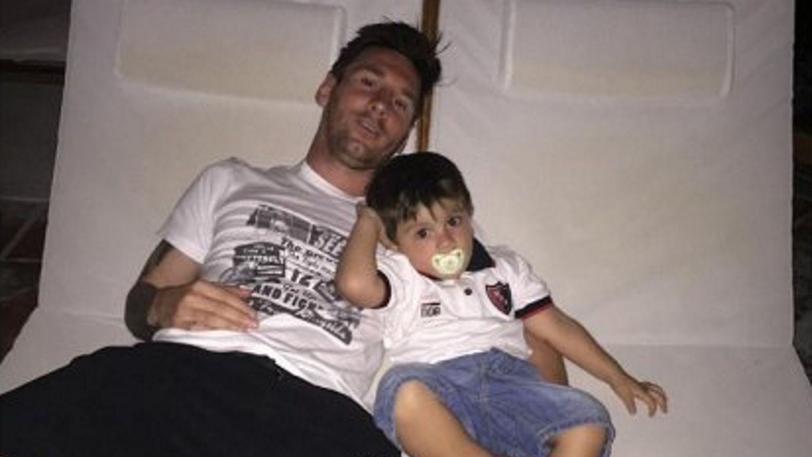 Thiago, con chupete y chomba de la Lepra junto a su papá, Lionel