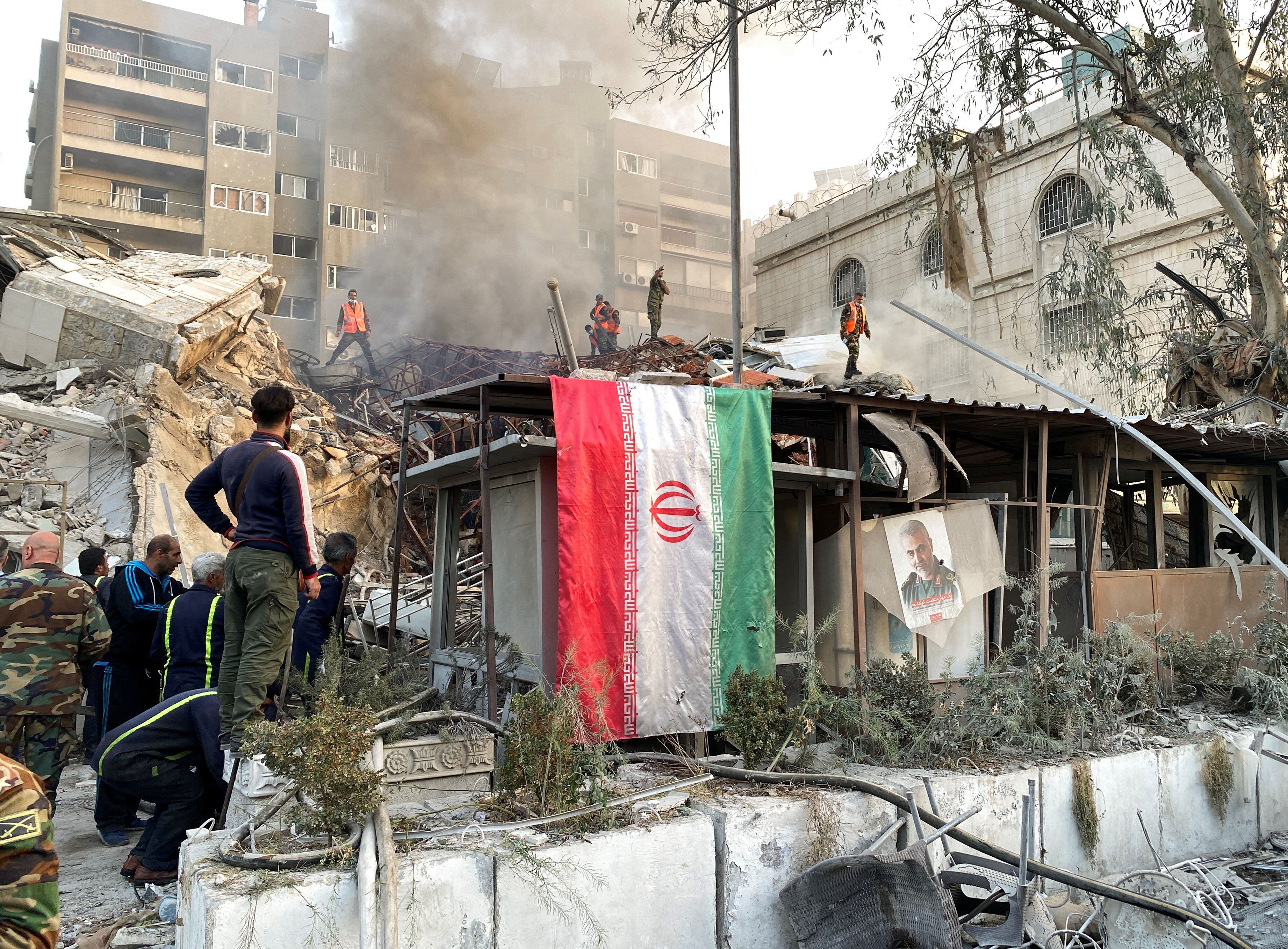 Una bandera iraní cuelga del edificio atacado por un bombardeo atribuido a Israel (REUTERS/Firas Makdesi)