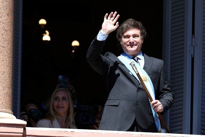 El presidente Javier Milei saluda desde un balcón de la Casa Rosada el día de su asunción  