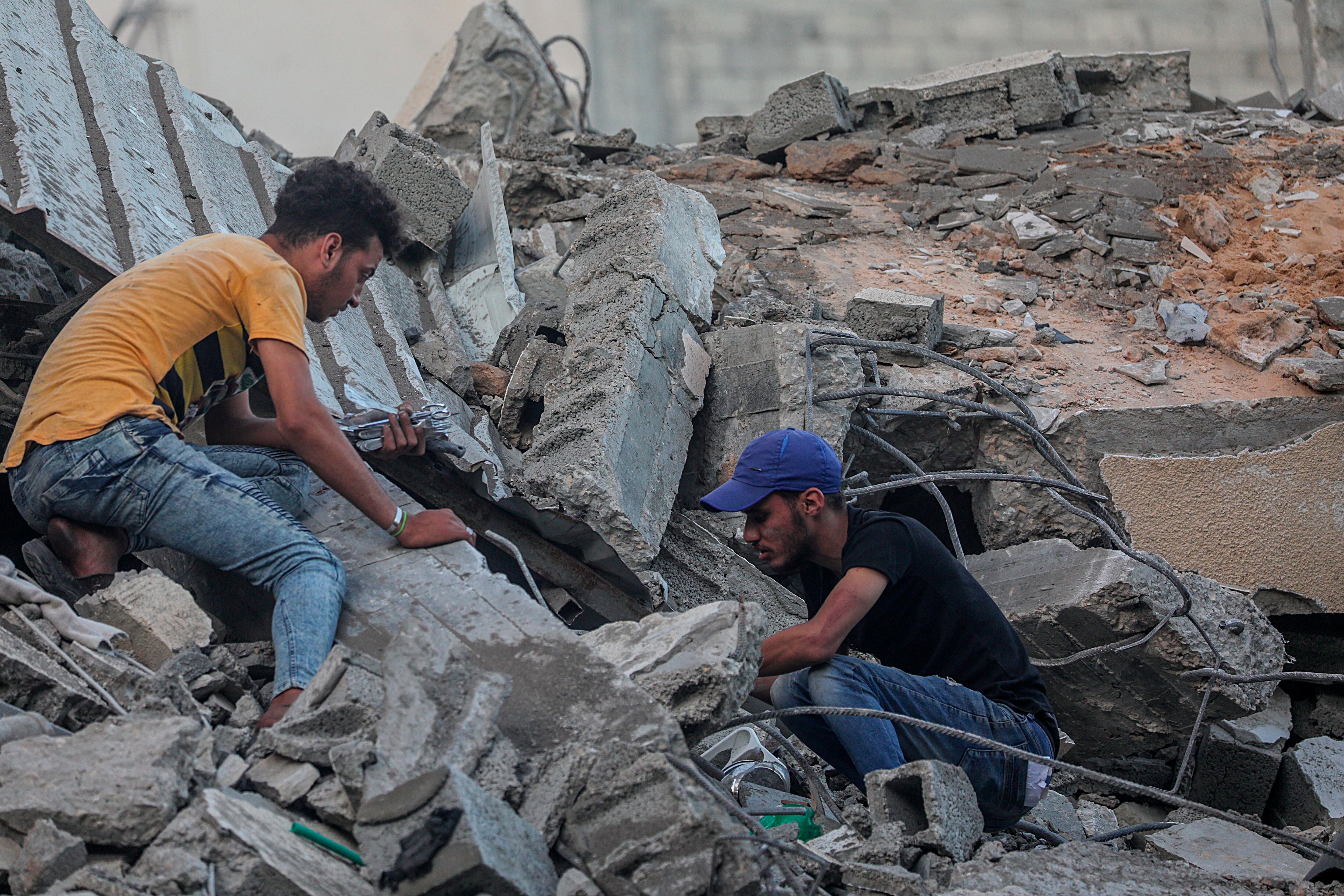 Palestinos inspeccionan los escombros de su casa destruida después de los ataques aéreos israelíes, en la ciudad de Gaza, el 19 de mayo de 2021. EFE/EPA/MOHAMMED SABER 