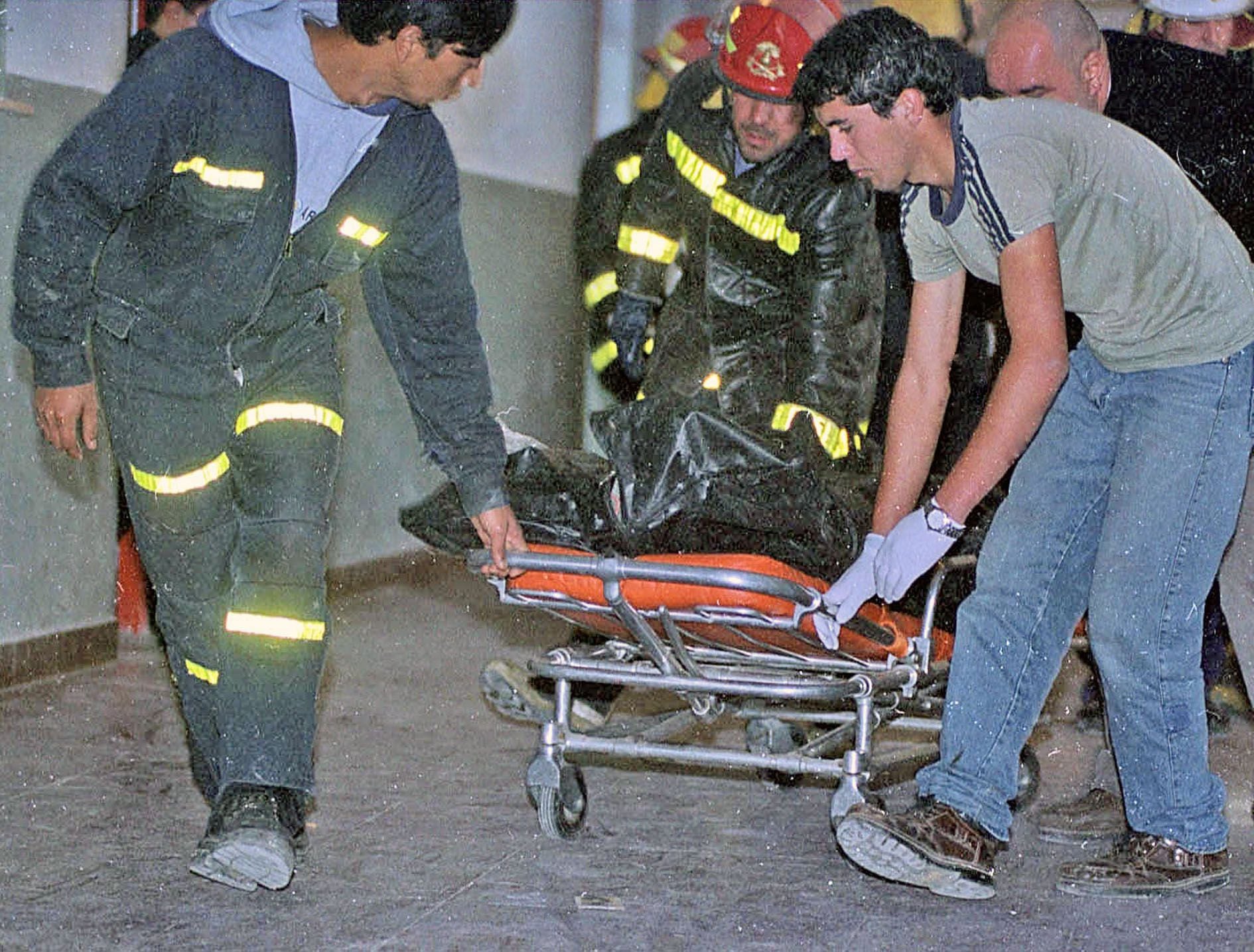 Bomberos trasladan el cuerpo de uno de los tres alumnos asesinados en la escuela Islas Malvinas donde un alumno mato a tres compañeros e hirio a otros cinco, a la morgue del hospital de Carmen de Patagones (Foto NA: gentileza diario Rio Negro/MARCELO OCHOA)