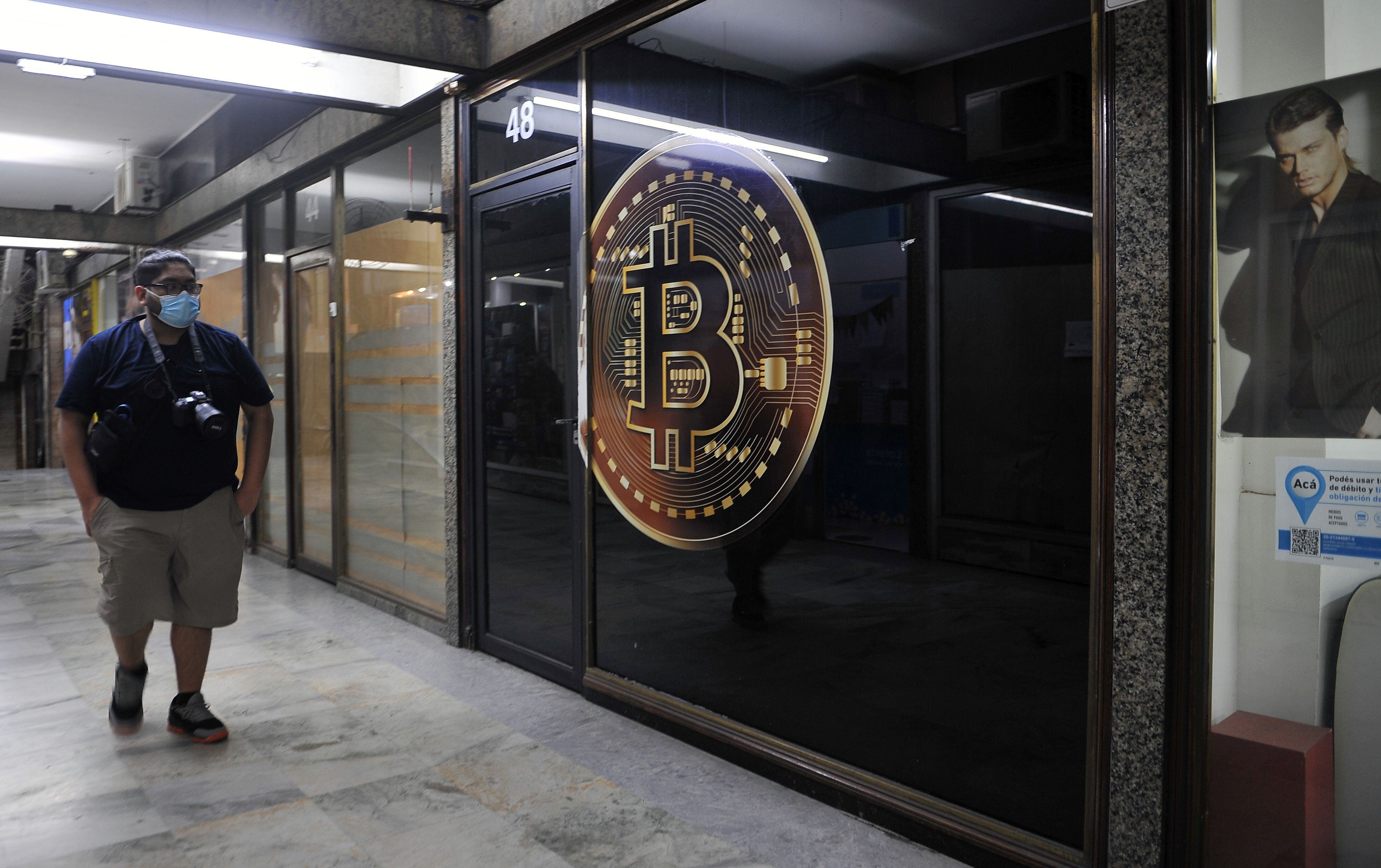 Un hombre camina frente a una tienda de criptomonedas el en la zona bancaria de Buenos Aires, en una fotografía de archivo. EFE/Enrique García Medina
