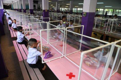 Estudiantes de la escuela Wichuthit en Bangkok, Thailand almuerzan respetando la distancia y con protección - REUTERS/Chalinee Thirasupa