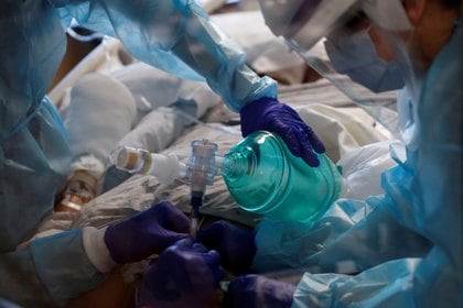 Trabajadores de cuidados intensivos insertan un tubo endotraqueal en un paciente con enfermedad por coronavirus (COVID-19) positivo en la unidad de cuidados intensivos (UCI) del Sarasota Memorial Hospital en Sarasota, Florida, el 11 de febrero de 2021. REUTERS / Shannon Stapleton