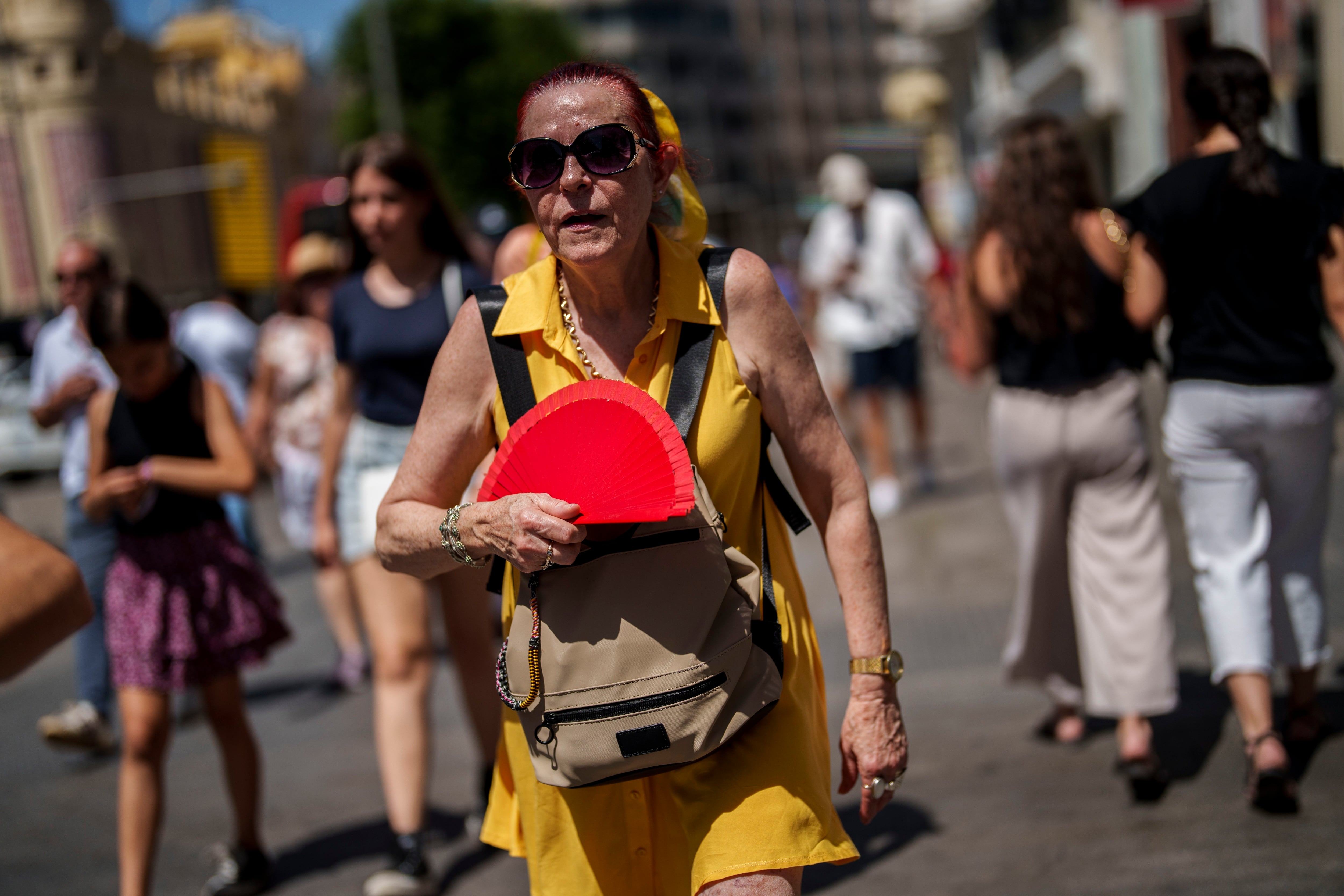 Una mujer se abanica bajo un sol abrasador en Madrid, España (AP Foto/Manu Fernández)