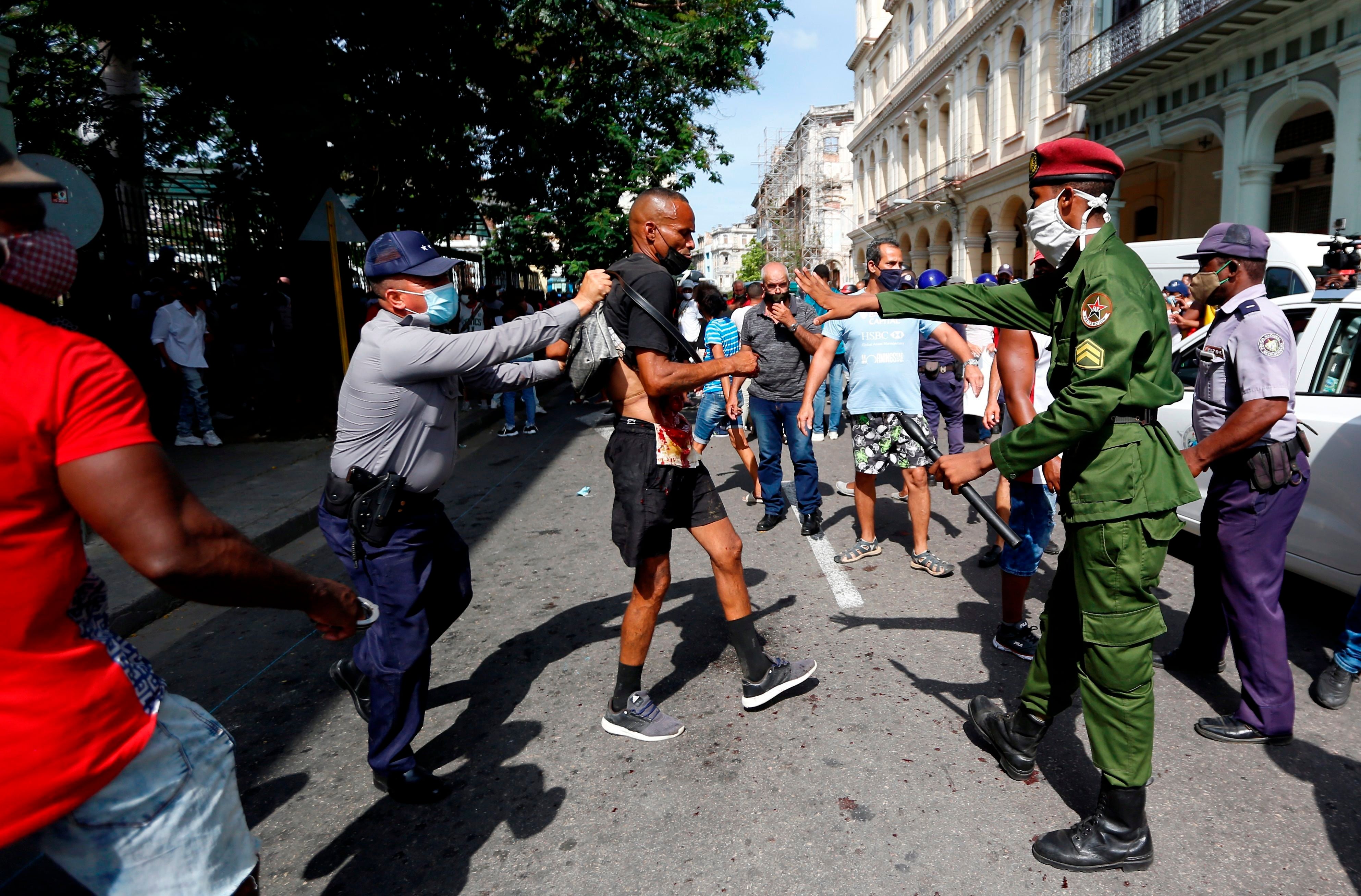 Policías arrestan a un hombre cuando personas se manifiestan hoy, en una calle en La Habana (Cuba). EFE/Ernesto Mastrascusa
