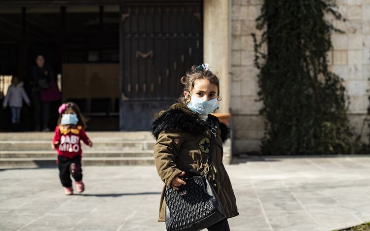 Dos niñas con tapabocas en Siria (AFP)