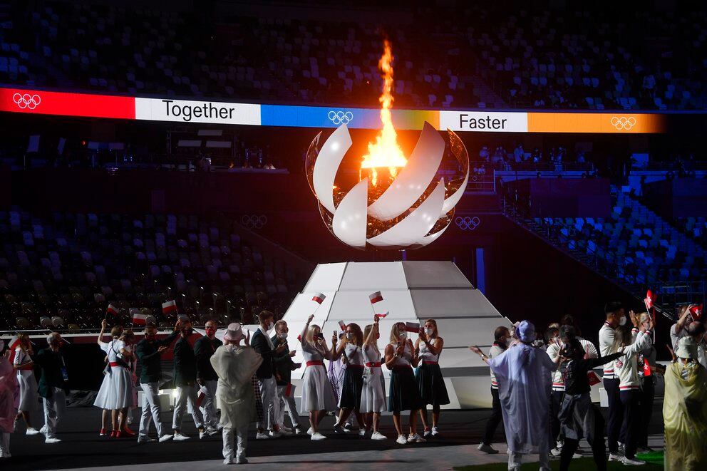 La alcalde de París, Anne Hidalgo, flamea la bandera olímpica. Aplaude el presidente del Comité Olímpico Internacional, Thomas Bach (REUTERS/Antonio Bronic)