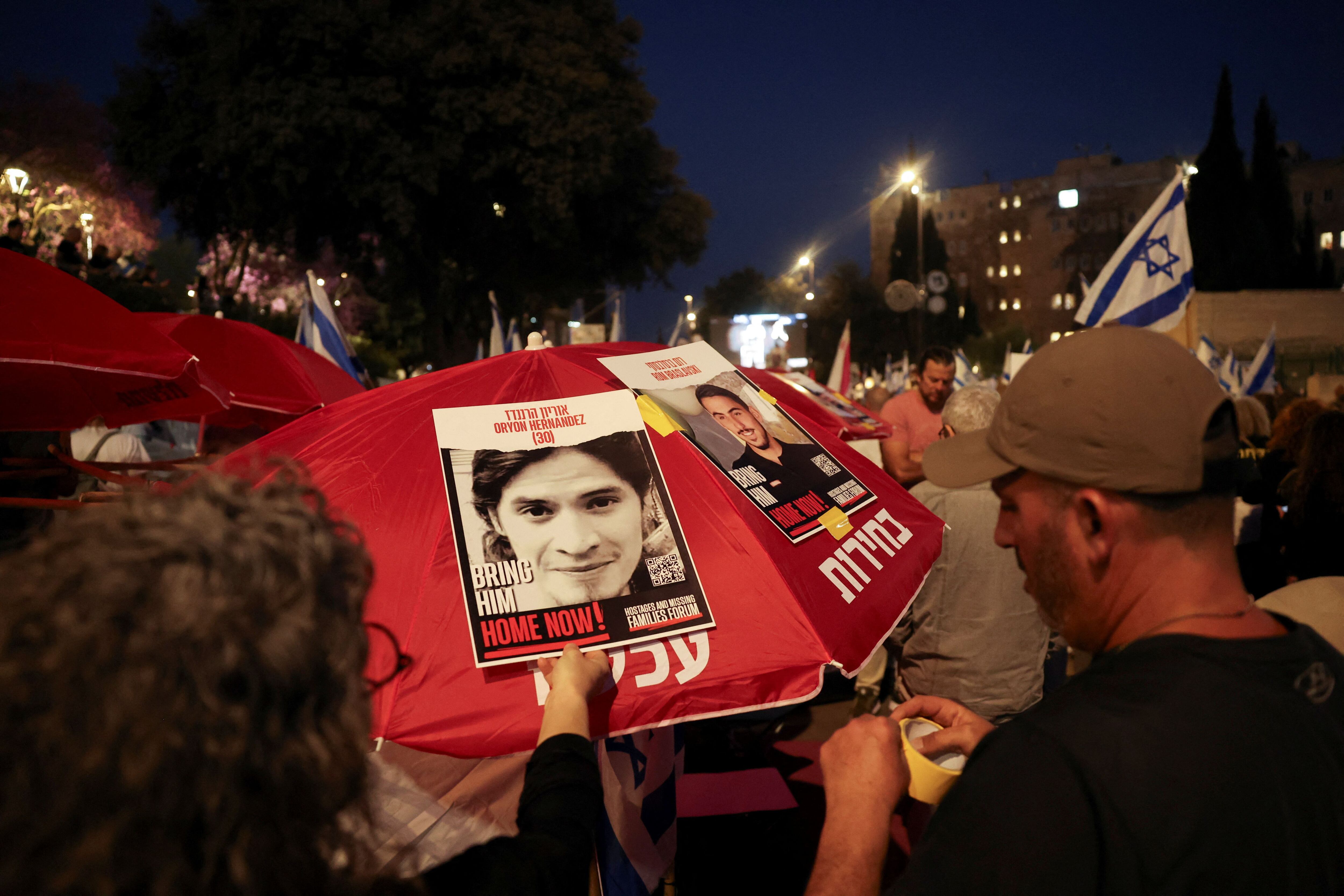 Una mujer sostiene un cartel con la imagen de un rehén secuestrado en el mortal ataque del 7 de octubre contra Israel por parte del grupo islamista palestino Hamas desde Gaza, mientras los manifestantes exigen el derrocamiento del Primer Ministro israelí Benjamín Netanyahu, tras el mortal ataque del 7 de octubre y la Guerra resultante en Gaza, en una manifestación en Jerusalén, el 1 de abril de 2024. REUTERS/Ronen Zvulun