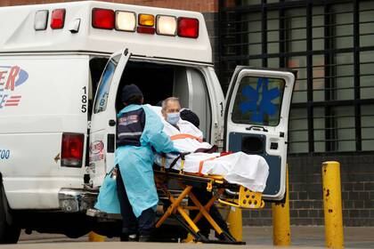 Paramédicos subiendo a un paciente a una ambulancia afuera del Elmhurst Hospital Center, durante la pandemia del COVID-19, la enfermedad causada por el coronavirus, en el distrito de Queens  (Reuters)