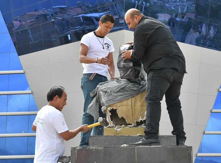Ciudadanos retiran un busto de Evo Morales cubierto con una tela en Quillacollo (EFE/Jorge Abrego)
