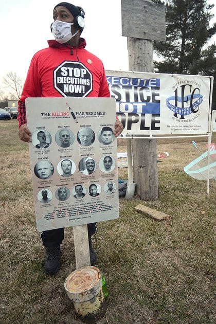 En una protesta por la ejecución de Corey Johnson, el jueves 14 de enero de 2021, cerca del Complejo Correccional Federal en Terre Haute, Indiana, Charles Keith, de Canton, Ohio, sostiene un cartel con todas las fotos policiales de los 10 hombres y una mujer que ha sido ejecutada por el gobierno federal desde el 14 de julio de 2020 (Joseph C. Garza / The Tribune-Star vía AP)