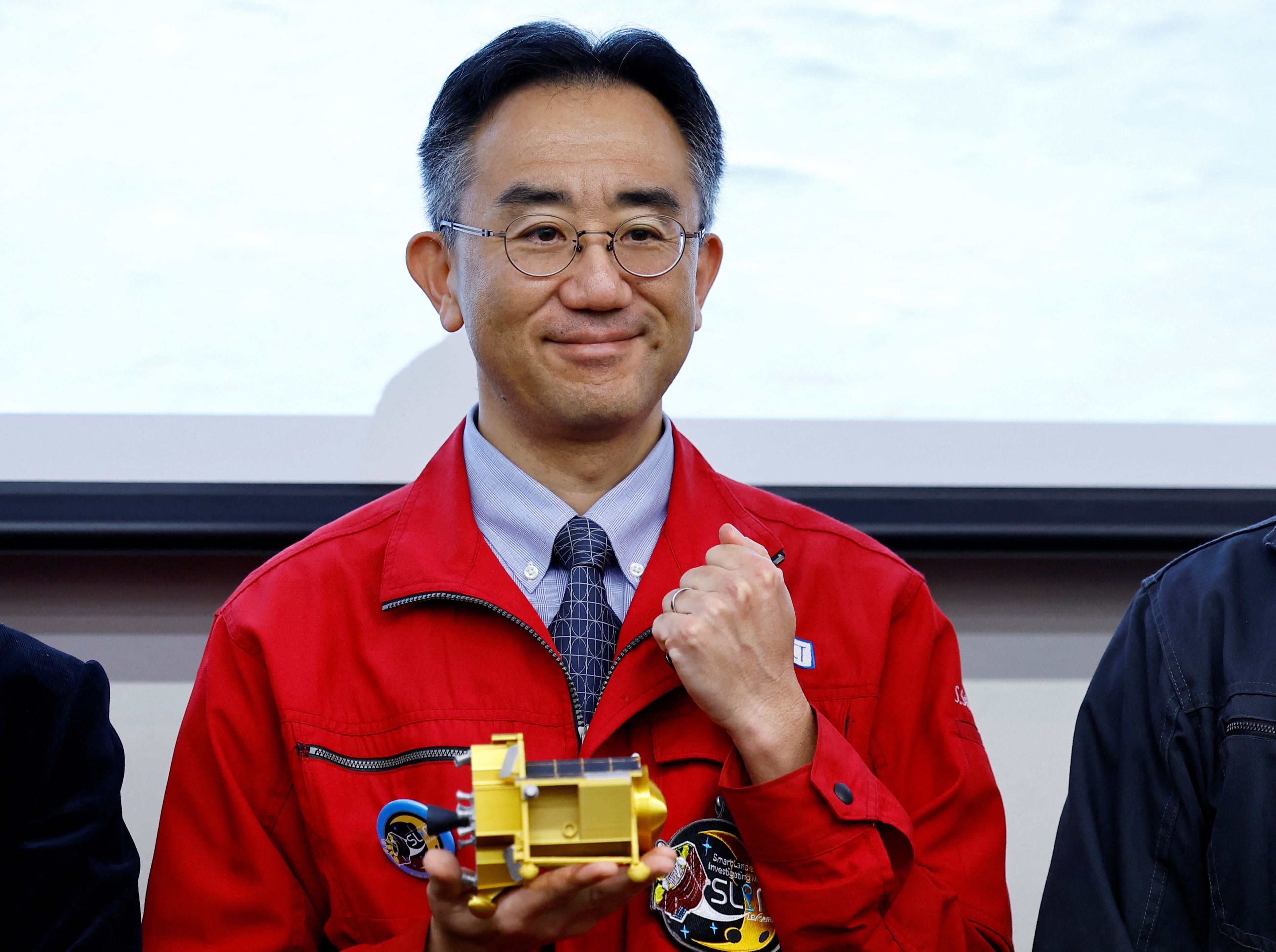 Shinichiro Sakai, director de proyecto del SLIM de la Agencia de Exploración Aeroespacial de Japón (JAXA), posa con un modelo en miniatura del aparato. (REUTERS/Kim Kyung-Hoon)