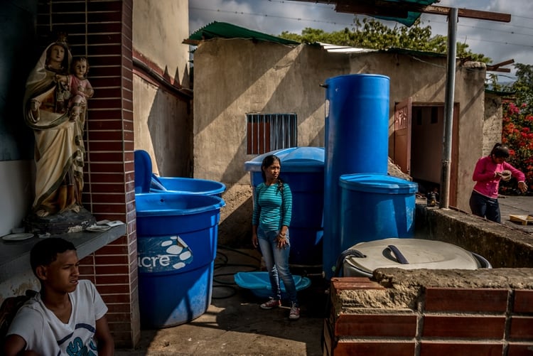 Esmeralda Nava dijo que no ha tenido agua potable en su casa desde hace dieciocho meses. Ella y sus vecinos en Caracas usan tambos azules para almacenar el agua. (Meridith Kohut/The New York Times)