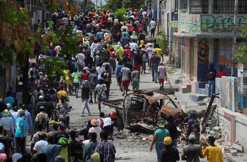 Personas marchan por el barrio de Carrefour Feuilles, que quedó desierto debido a la violencia de las bandas en Puerto Príncipe, Haití, el 19 de marzo de 2024 (REUTERS/Ralph Tedy Erol)