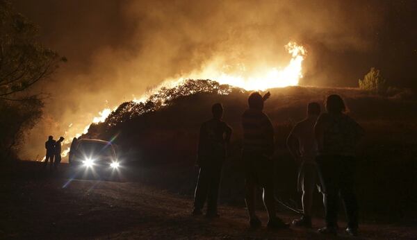 La gente observa las llamas en las afueras de Obidos (AP Photo/Armando Franca)