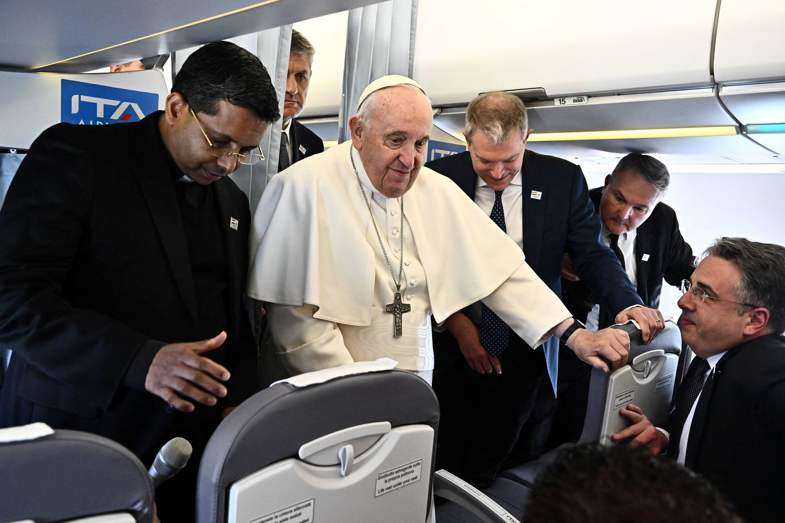 El papa Francisco, flanqueado por el portavoz del Vaticano, Matteo Bruni, habla con los periodistas a bordo de un vuelo de Roma a Budapest, 28 de abril de 2023. LUCA ZENNARO/Pool vía REUTERS/Archivo