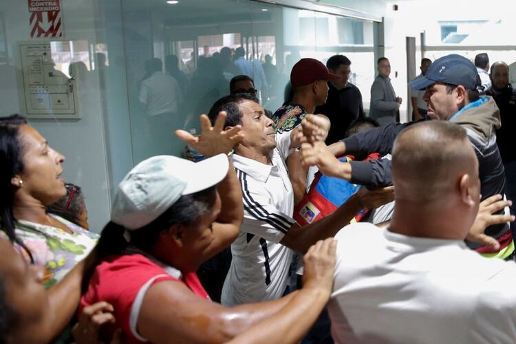 Foto del martes de seguidores del líder opositor Juan Guaido y del mandatario Nicolas Maduro se enfrentan en el aeropuerto Simon Bolivar en Maiquetia (REUTERS/Manaure Quintero)