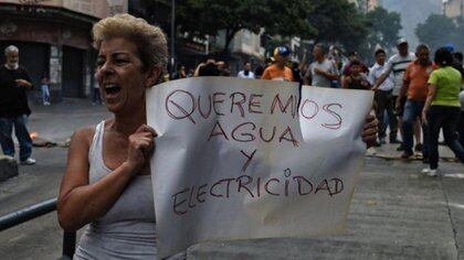 Una mujer enseña una pancarta durante una protesta en Venezuela