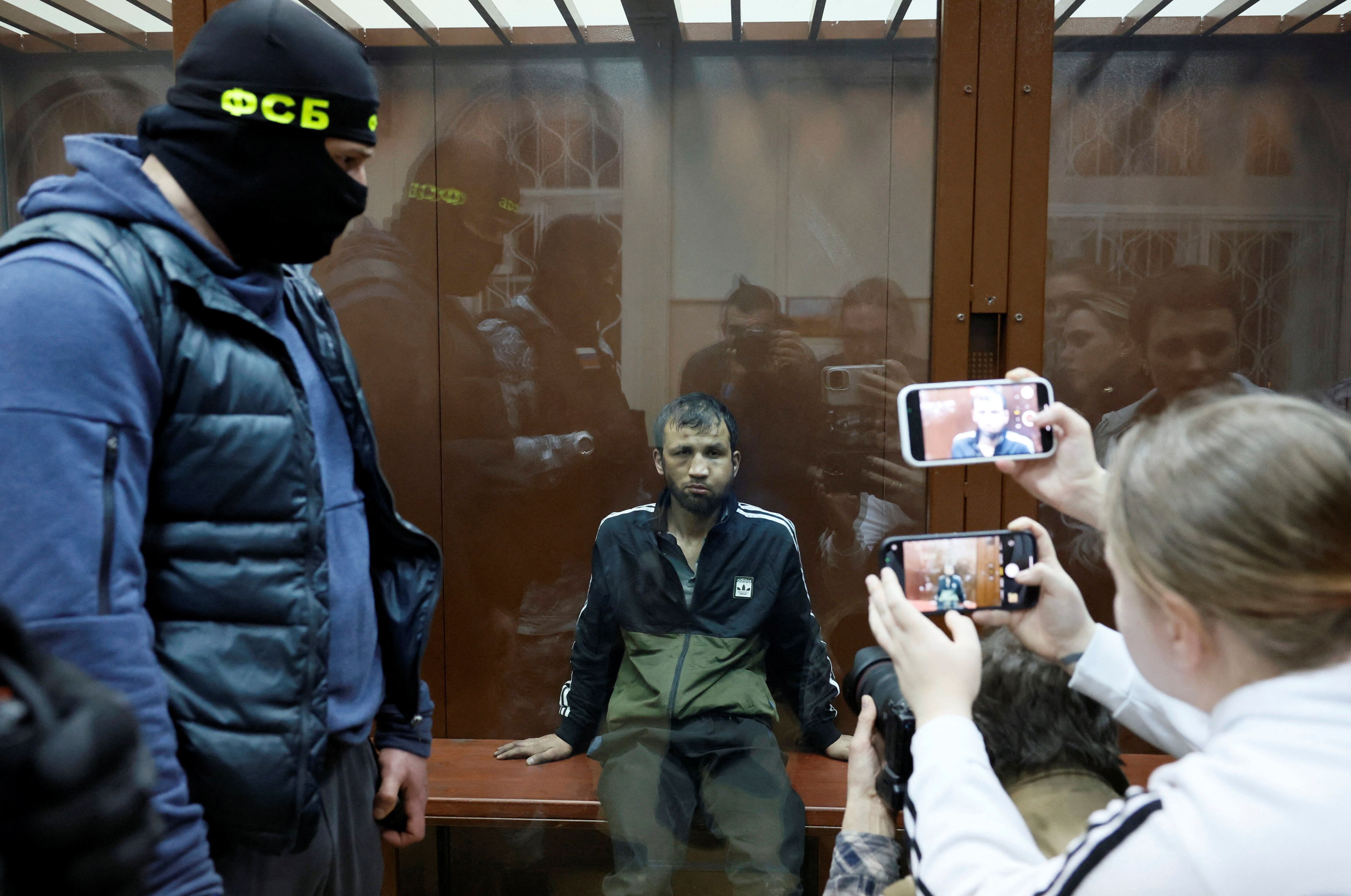 Shamsidin Fariduni, a suspect in the shooting attack at the Crocus City Hall concert venue, sits behind a glass wall of an enclosure for defendants before a court hearing at the Basmanny district court in Moscow, Russia March 25, 2024. REUTERS/Shamil Zhumatov