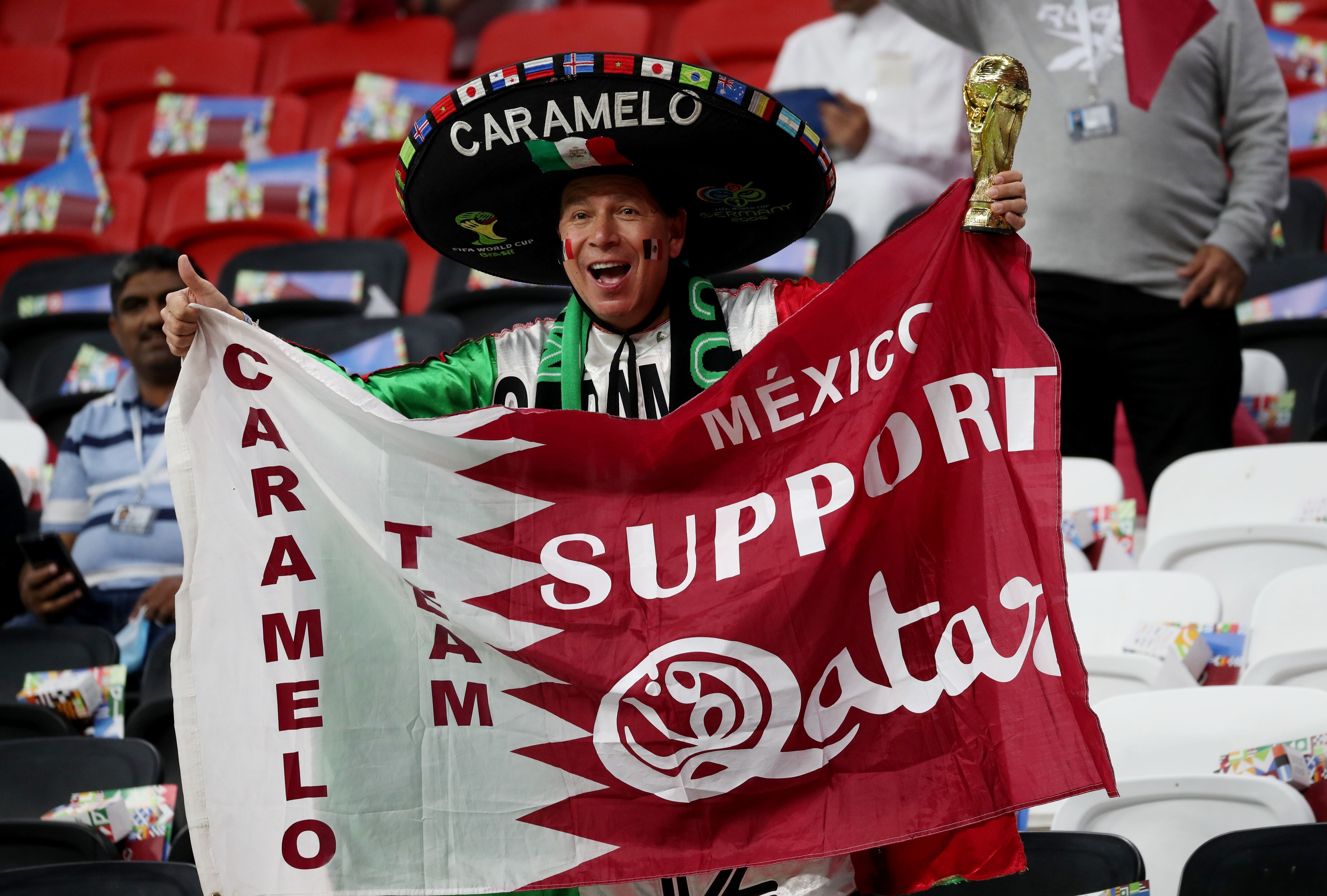 Soccer Football - Arab Cup - Group A - Qatar v Bahrain - Al Bayt Stadium, Al Khor, Qatar - November 30, 2021 Qatar fan holds a flag with a 'Mexico supports Qatar' message inside the stadium before the match REUTERS/Suhaib Salem