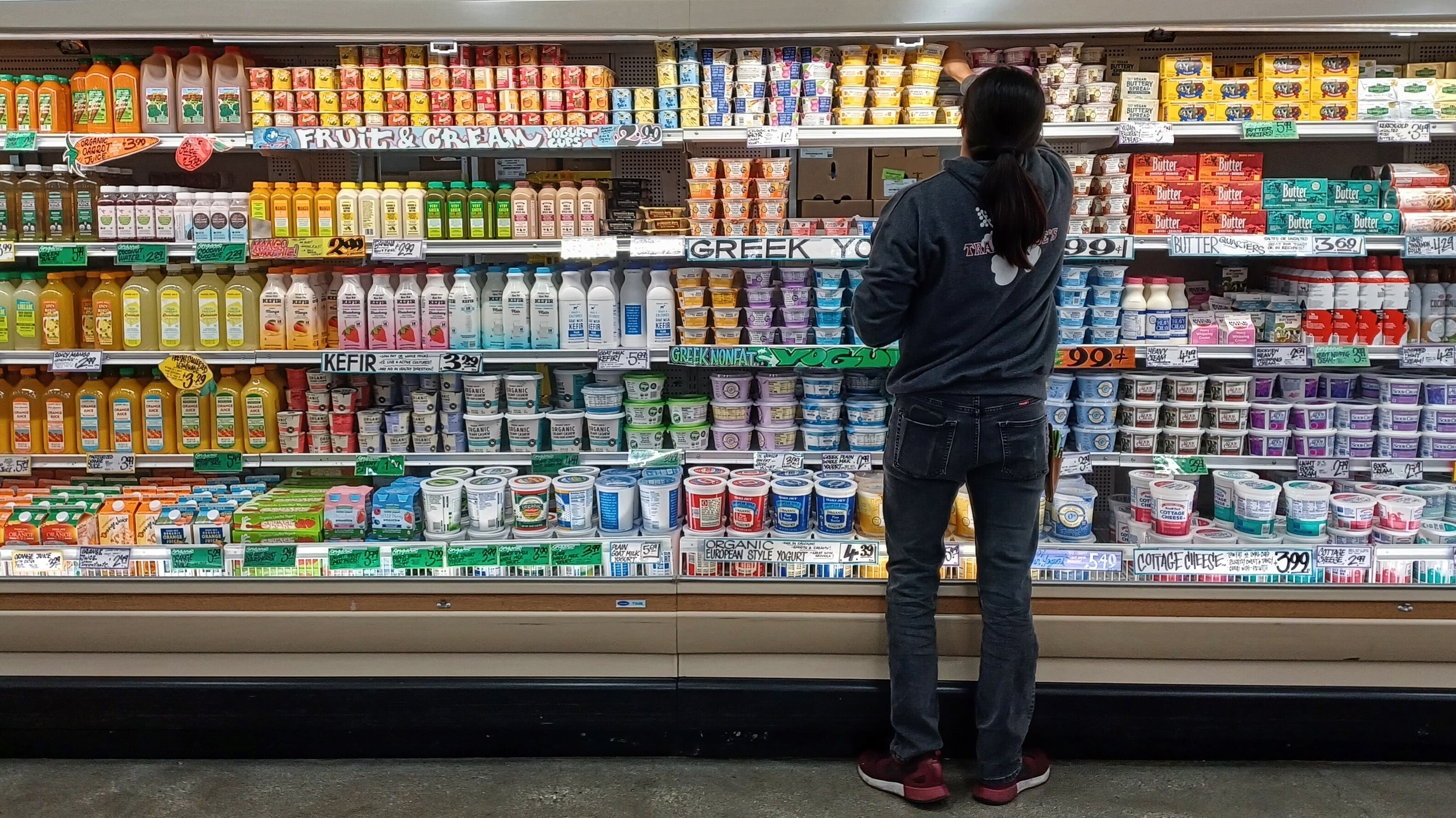 Un hombre frente a un estante de yogures en el supermercado (Shutterstock)