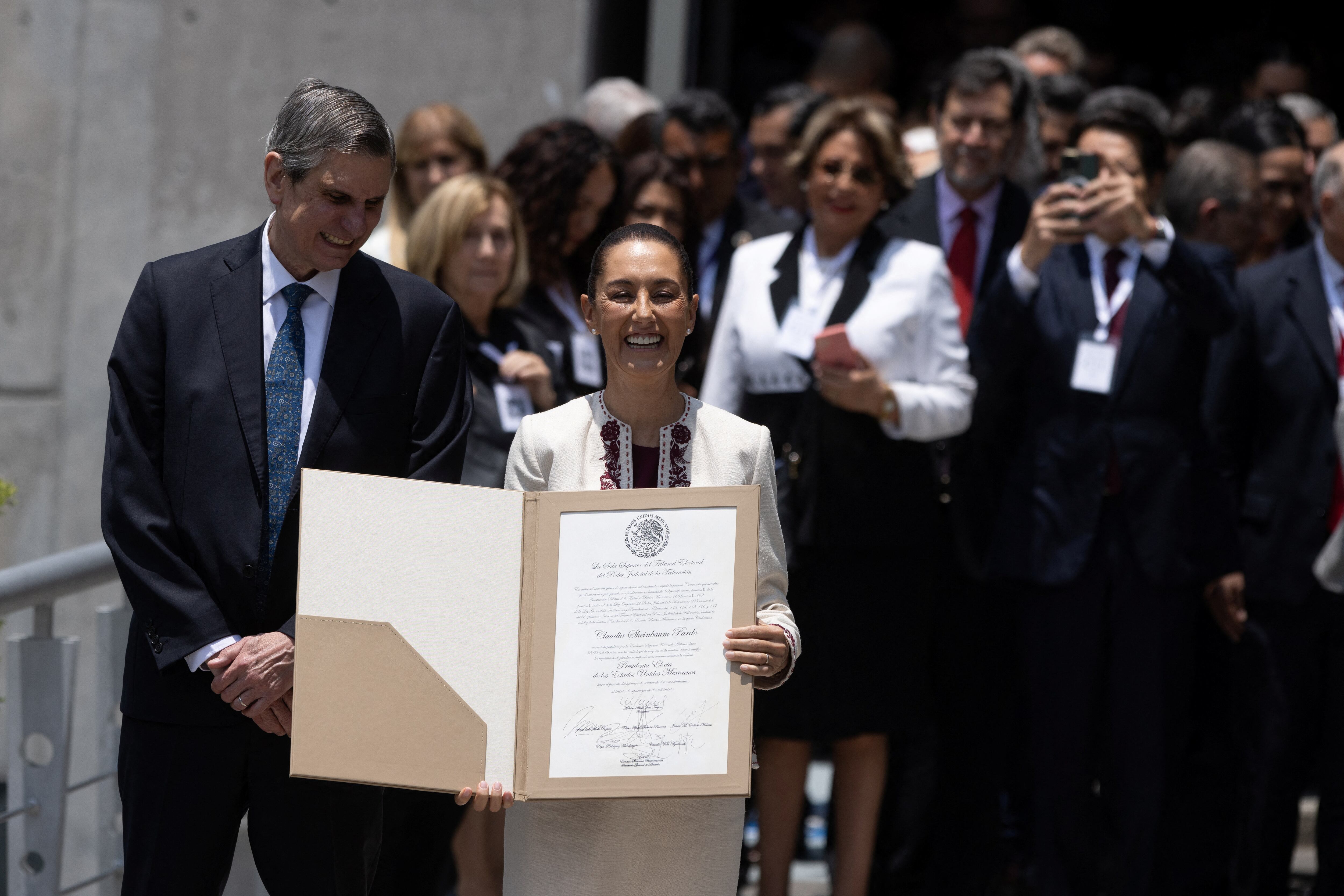 Mexico's President-elect Claudia Sheinbaum holds the certificate confirming her victory in the presidential election after it was handed by the President of the Federal Electoral Tribunal (TEPJF) Monica Soto Fregoso in Mexico City, Mexico August 15, 2024. REUTERS/Quetzalli Nicte-Ha