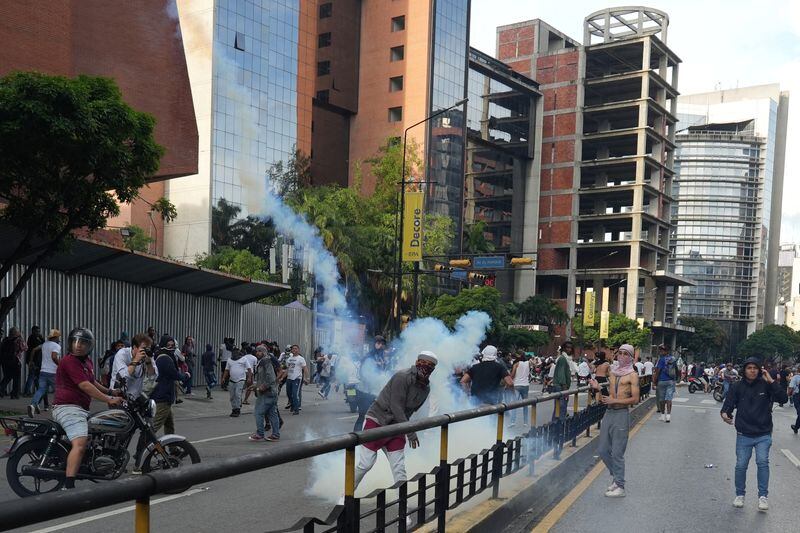 Un manifestante devuelve un bote de gas lacrimógeno mientras simpatizantes de la oposición venezolana protestan tras el anuncio del Consejo Nacional Electoral de que Nicolás Maduro ganó las elecciones, en Caracas (REUTERS/Alexandre Meneghini)