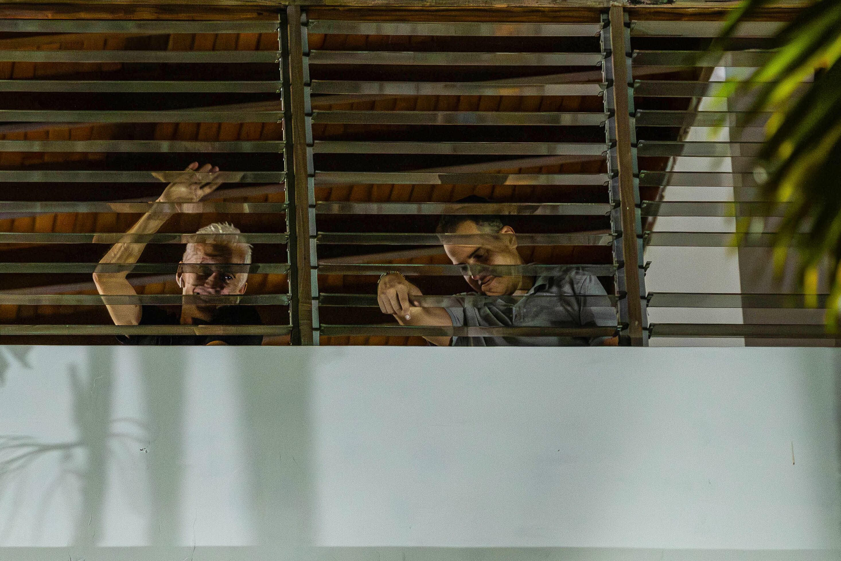 Dos de los seis opositores venezolanos que se encuentran refugiados en la residencia oficial de la embajada de Argentina en Caracas, saludan desde una ventana. Foto: EFE/ Henry Chirinos
