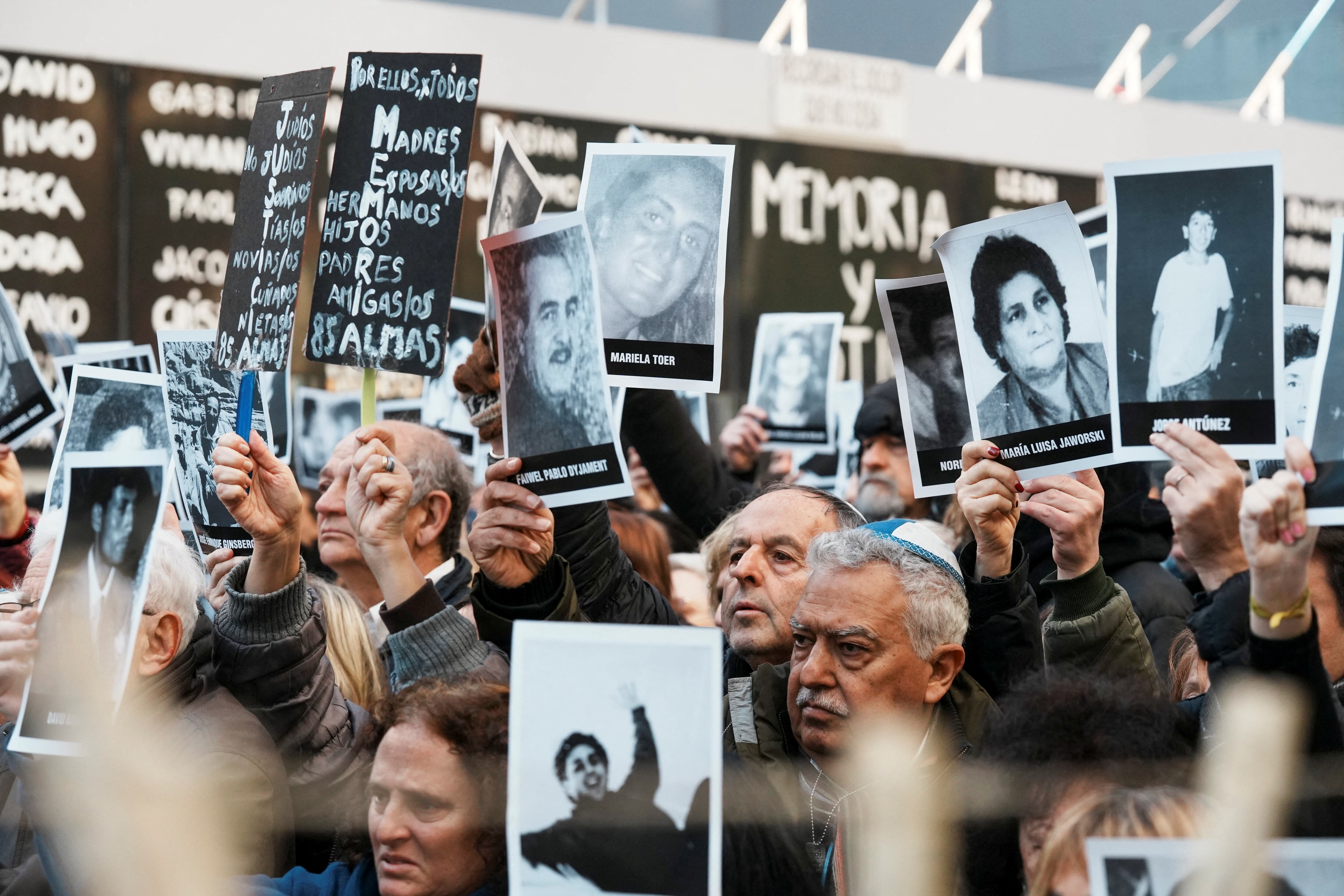 People hold images of the victims of the 1994 bombing attack on the Argentine Israeli Mutual Association (AMIA) community centre, marking the 30th anniversary of the attack, in Buenos Aires, Argentina July 18, 2024. REUTERS/Irina Dambrauskas