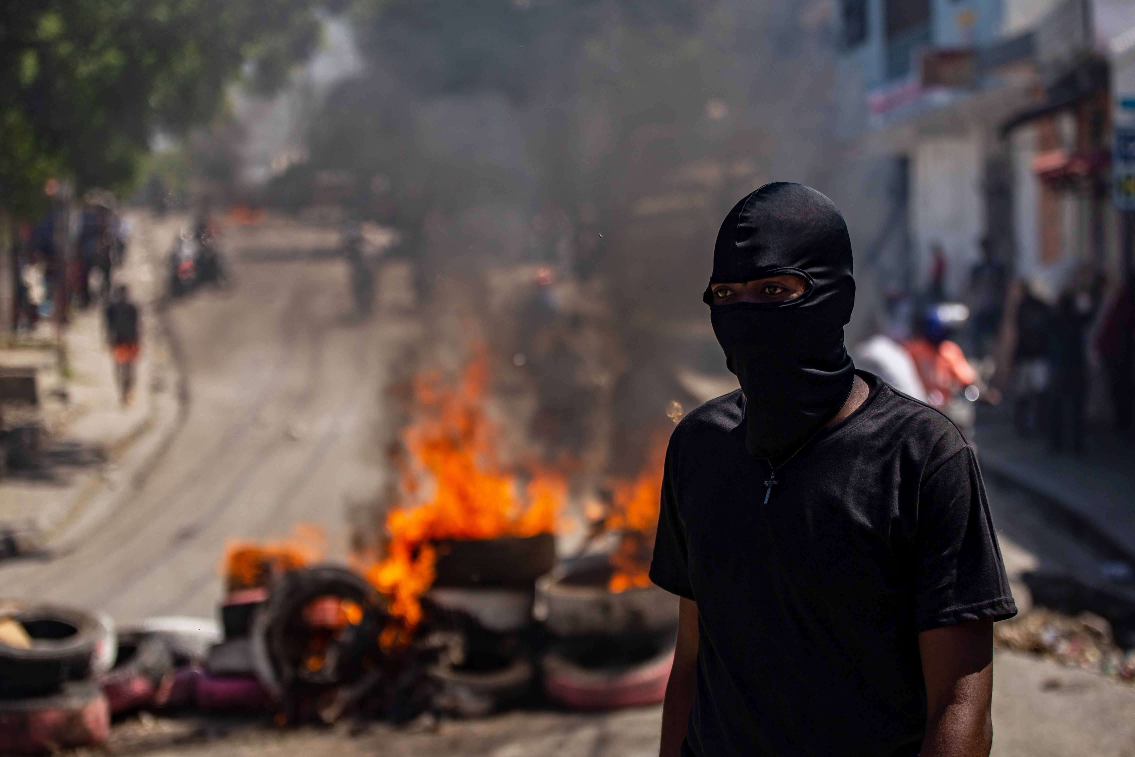 Fotografía de archivo de un manifestante que camina frente una barricada con fuego durante una protesta en el barrio Solino, en Puerto Principe, Haití (EFE/Mentor David Lorens)