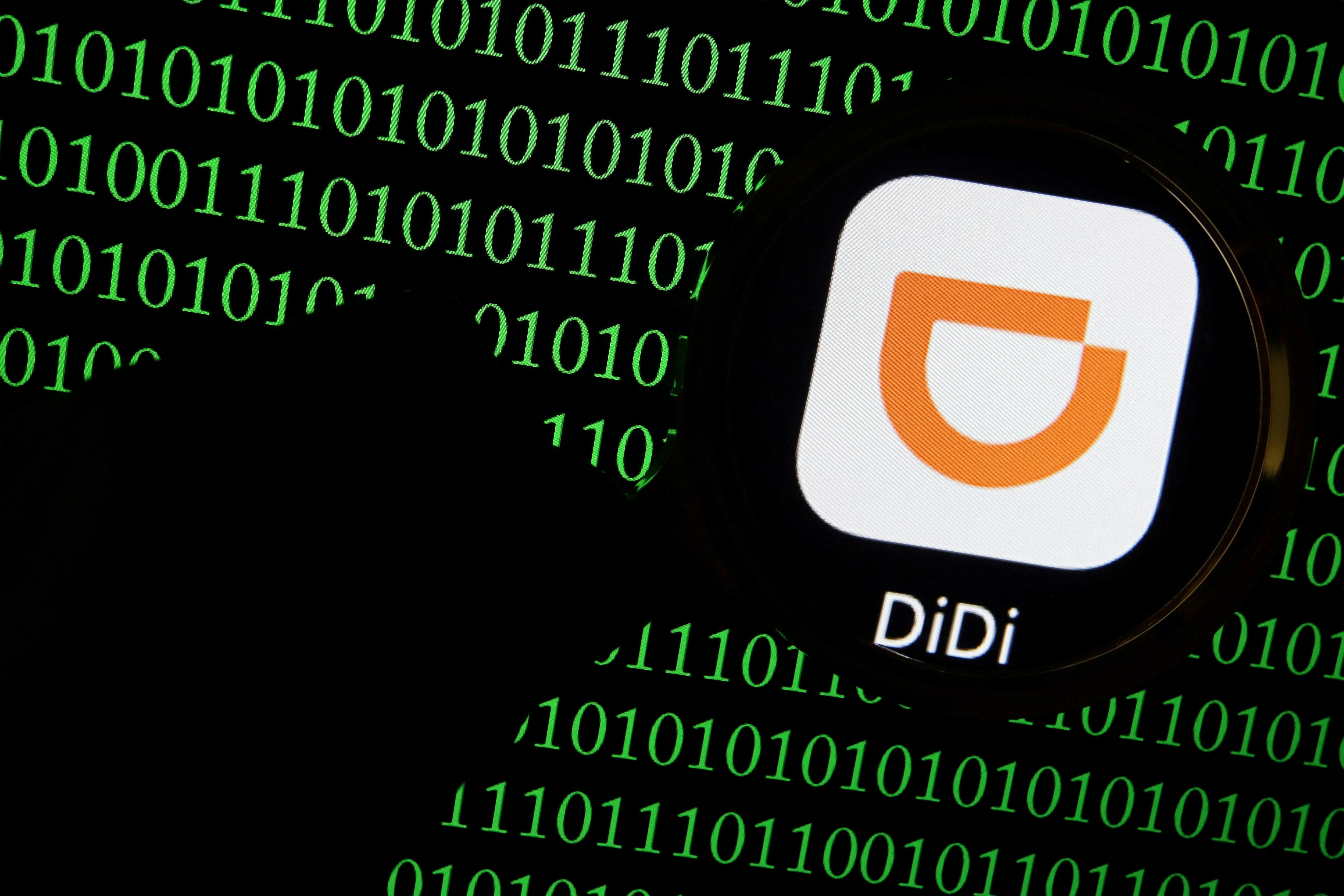 FILE PHOTO: The app logo of Chinese ride-hailing giant Didi is seen through a magnifying glass on a computer screen showing binary digits in this illustration picture taken July 7, 2021. REUTERS/Florence Lo/Illustration/File Photo