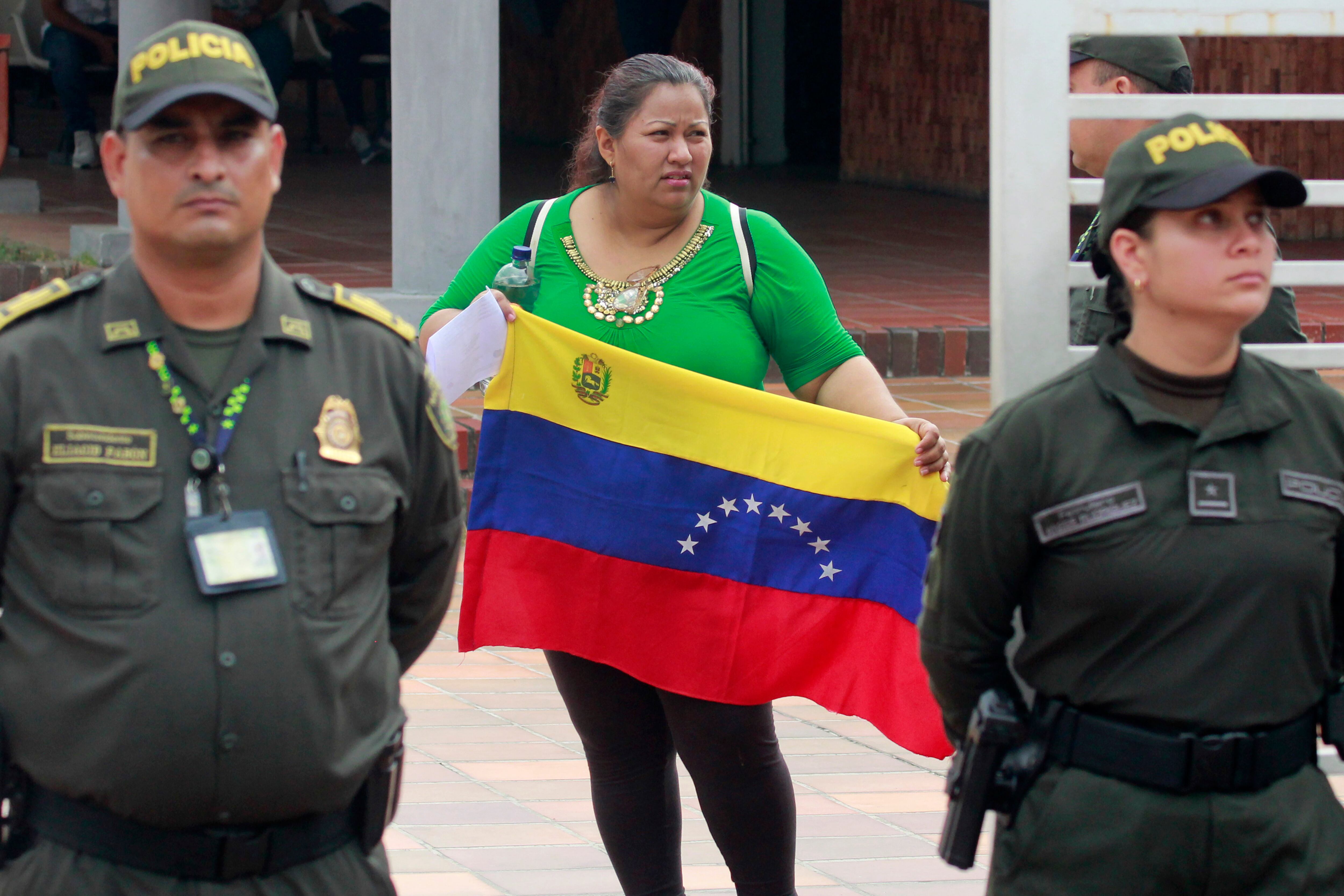 Una ciudadana venezolana sostiene la bandera de su país en el consulado de Venezuela que funciona como puesto de votación para las elecciones presidenciales de Venezuela este domingo en Cúcuta (Colombia). EFE/ Mario Caicedo
