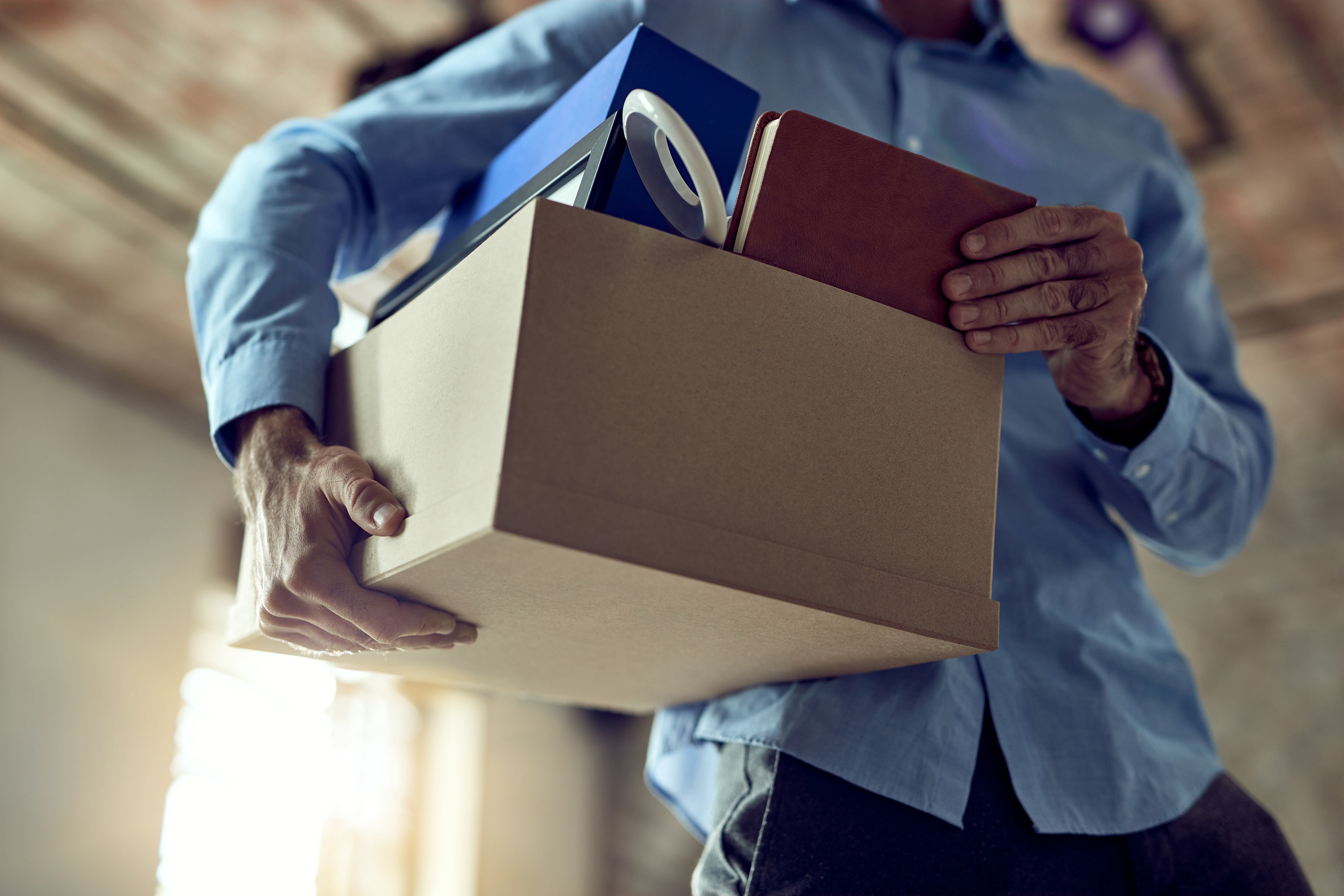 Hombre llevando sus cosas en una caja tras ser despedido (Freepik)