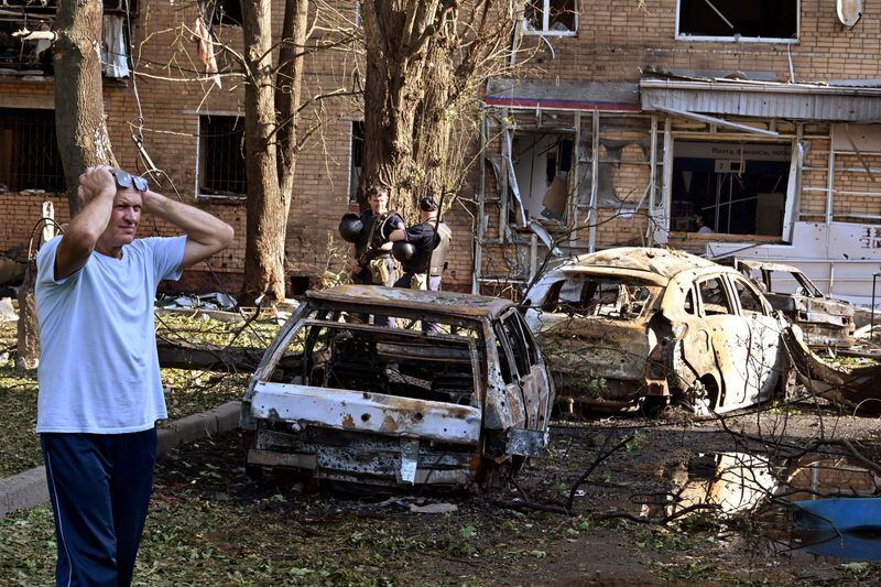 Un hombre reacciona junto a restos de coches quemados en el patio de un edificio residencial de varias plantas en Kursk (Kommersant Photo/Anatoliy Zhdanov vía REUTERS)