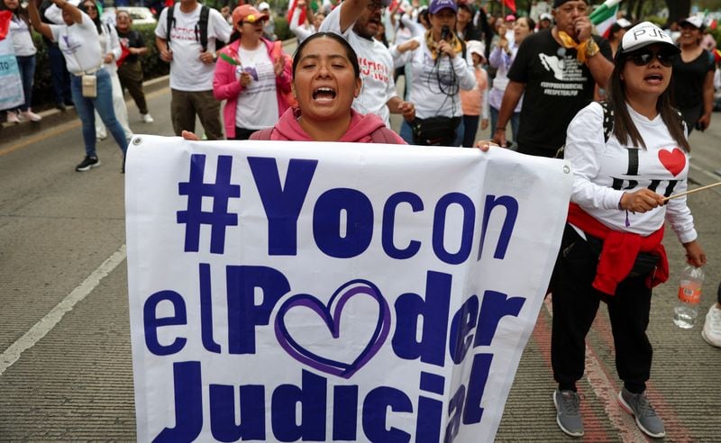 Una manifestante muestra una pancarta durante una protesta contra una controvertida reforma al Poder Judicial, que marcaría el comienzo de una nueva era de elecciones para todos los jueces, afuera del edificio del Senado en Ciudad de México. 8 de septiembre de 2024. REUTERS/Luis Cortés