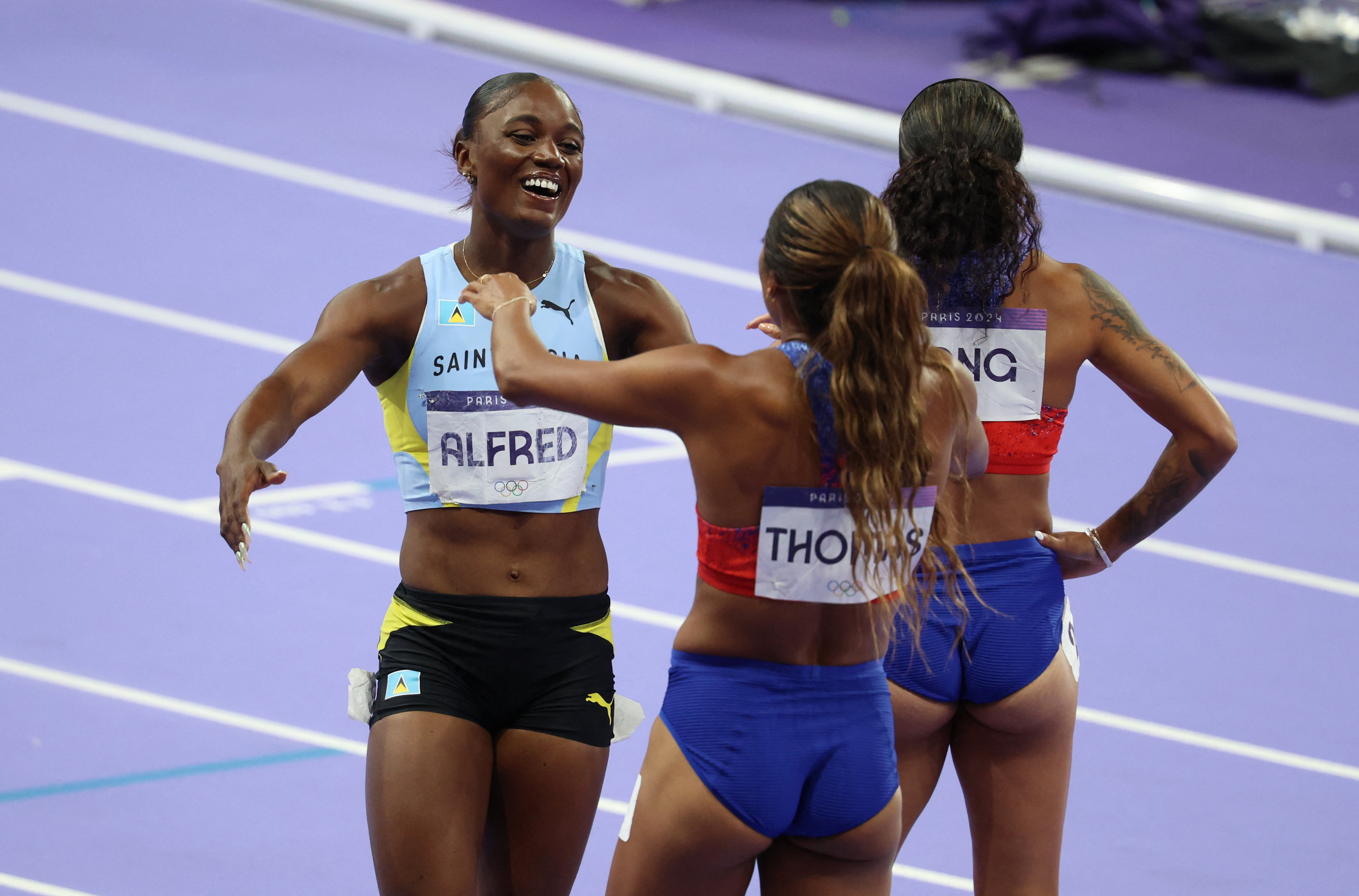 La corredora de Santa Lucía Julien Alfred celebra tras haber finalizado segunda en la final olímpica de 200 metros, que ganó la estadounidense Gabby Thomas (REUTERS/Phil Noble)