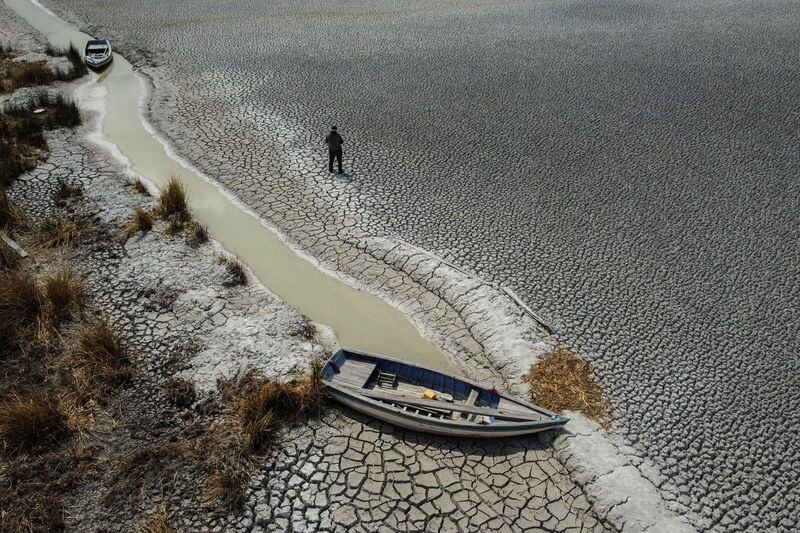 Un hombre caminando sobre un área seca que muestra la caída en el nivel del lago Titicaca, la cuenca de agua dulce más grande de América Latina, a medida que se acerca a niveles récord, en la isla Cojata, Bolivia. 26 de octubre de 2023. REUTERS/Claudia Morales