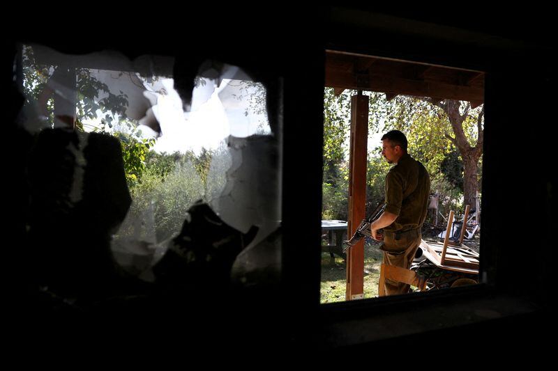 Un soldado israelí inspecciona una casa quemada el mortífero ataque del 7 de octubre perpetrado por Hamás (Reuters)