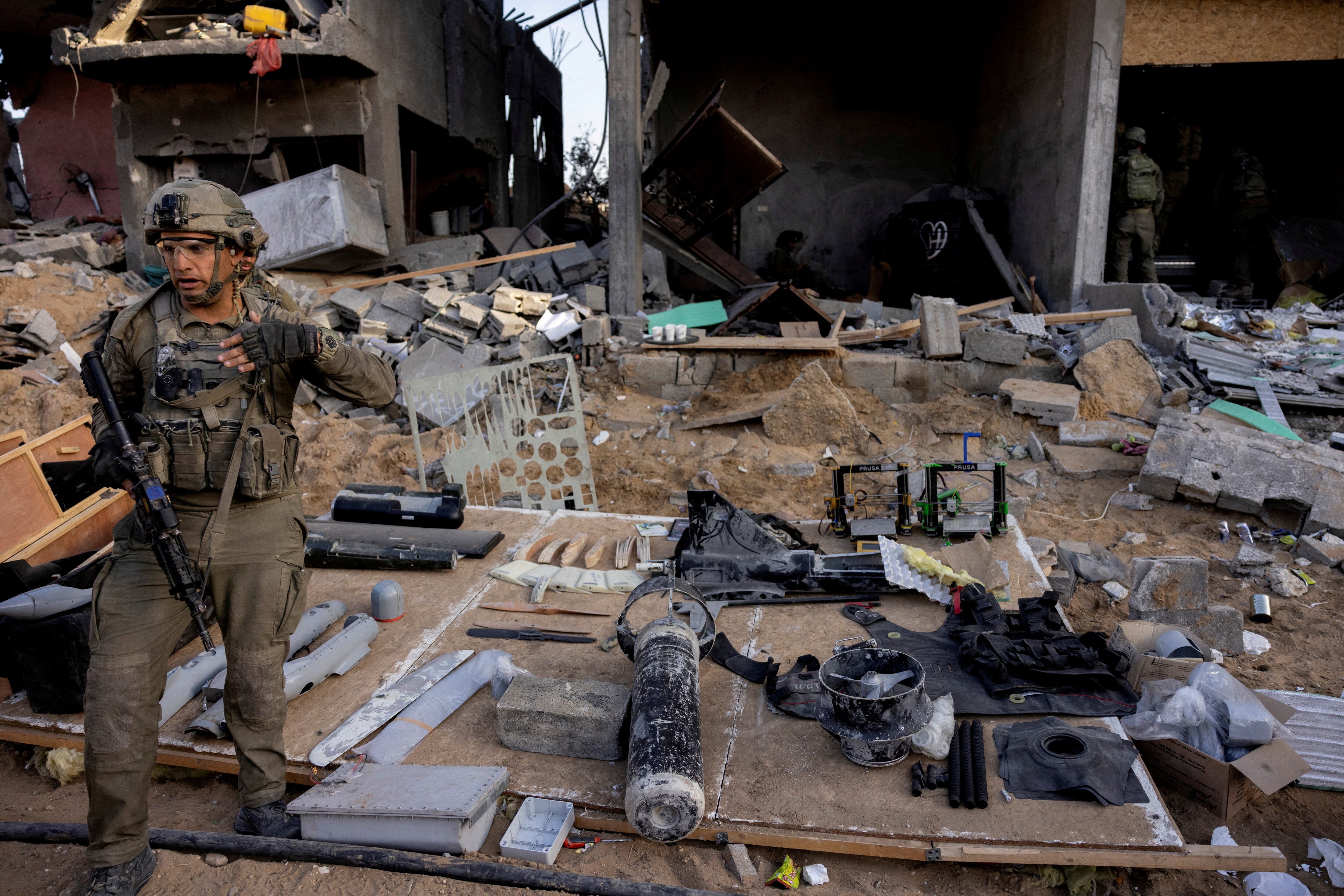 Un soldado israelí junto a los objetos hallados en el interior de un taller que, según afirman, se utilizaba para la fabricación de armas y estaba situado en los bajos de un edificio de viviendas. (REUTERS/Ronen Zvulun)