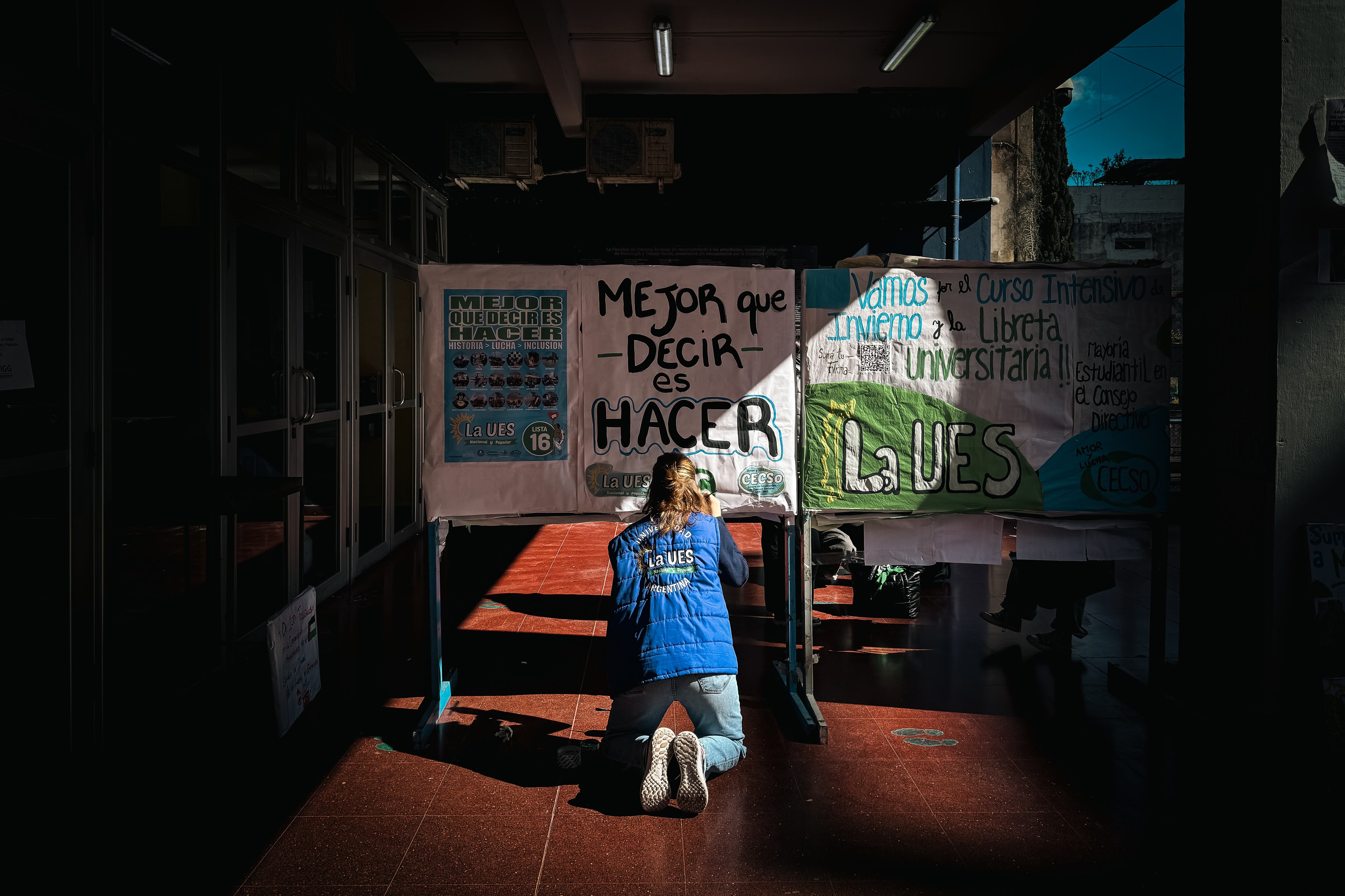 Una mujer pinta un cartel en la Facultad de Ciencias Sociales de la Universidad de Buenos Aires UBA (EFE/ Juan Ignacio Roncoroni)