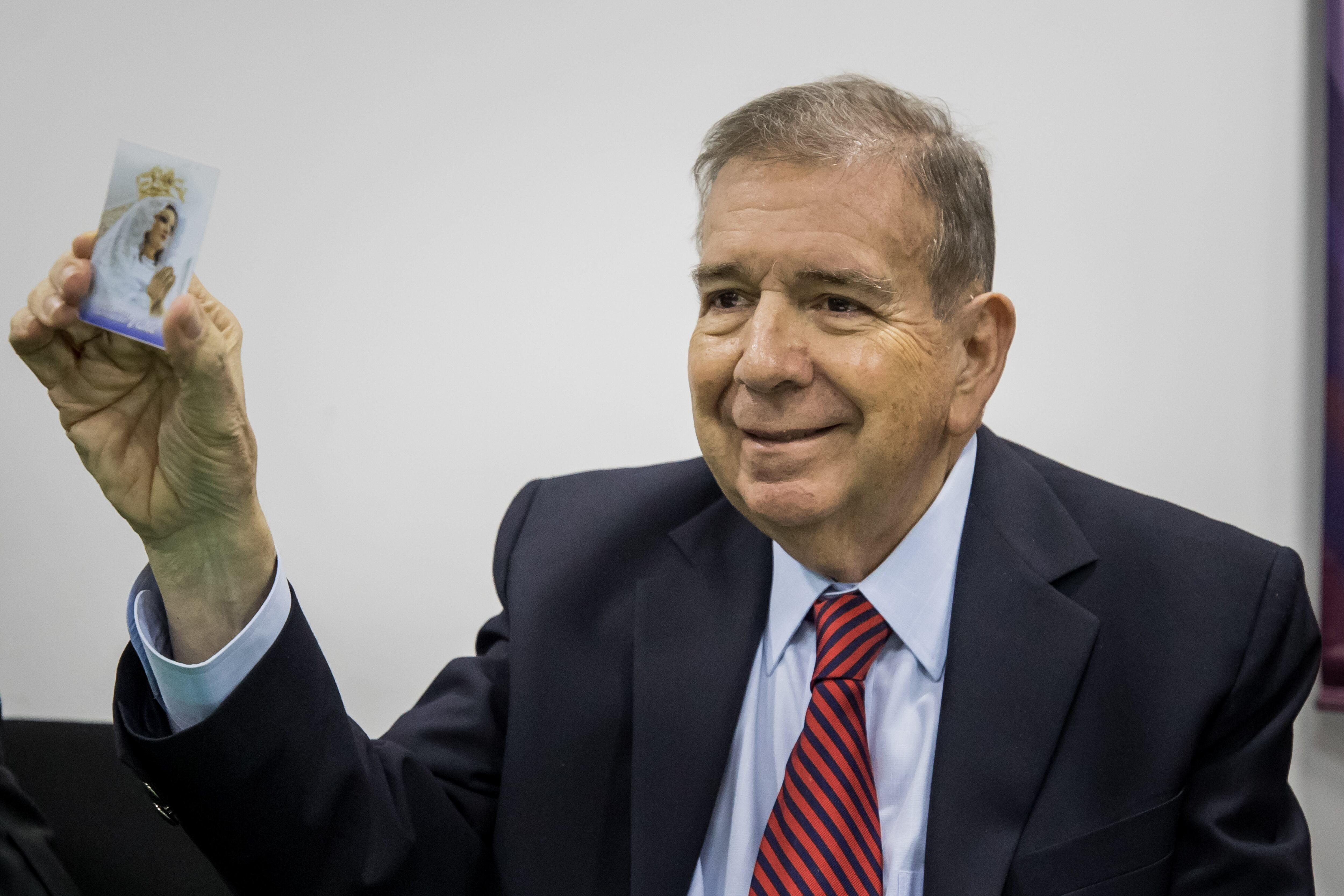 El candidato presidencial opositor Edmundo González Urrutia enseña una estampa de la Virgen del Valle, advocación de la Virgen María originada en el Estado de Nueva Esparta (EFE/Miguel Gutiérrez)