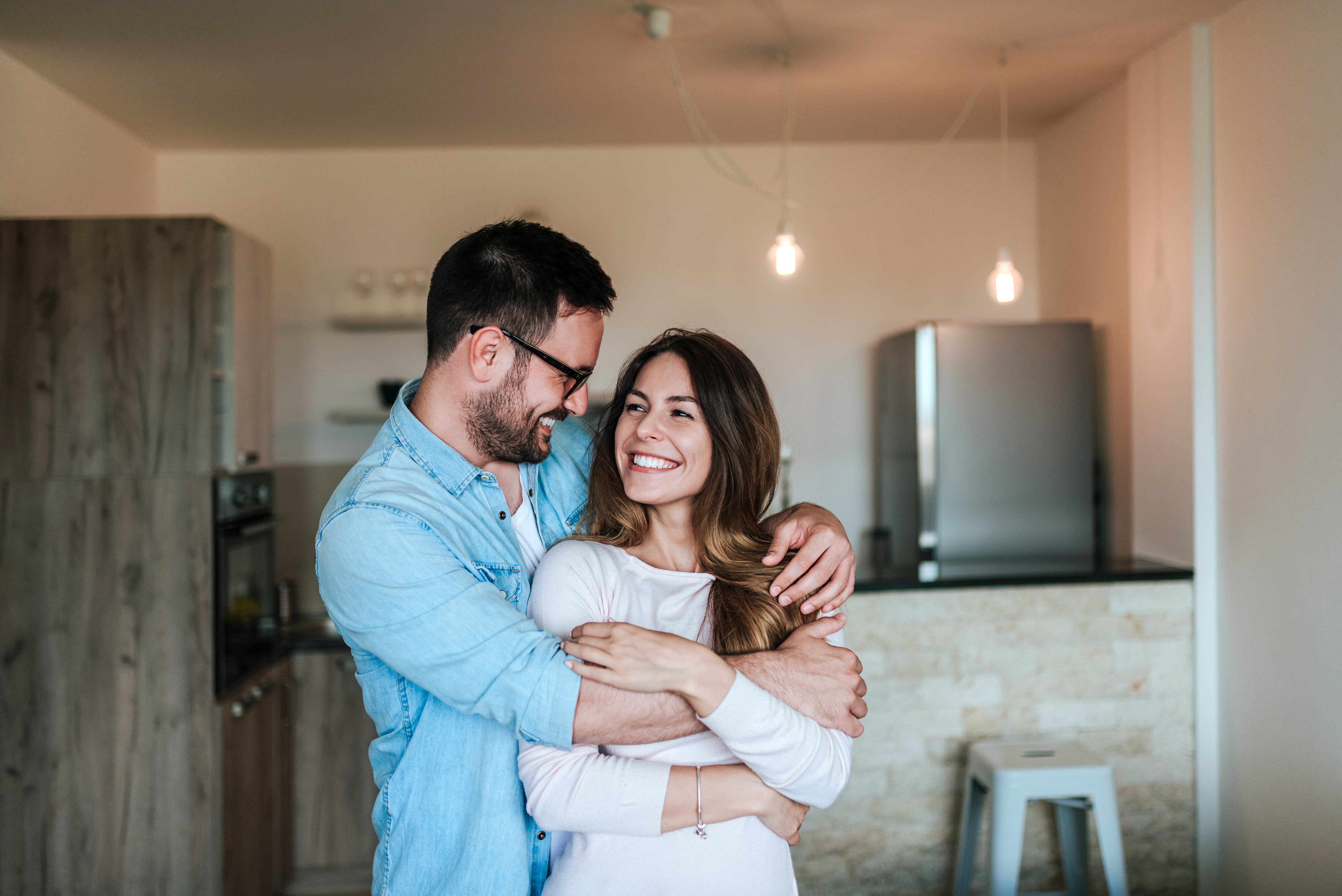 Una pareja abrazándose en su casa