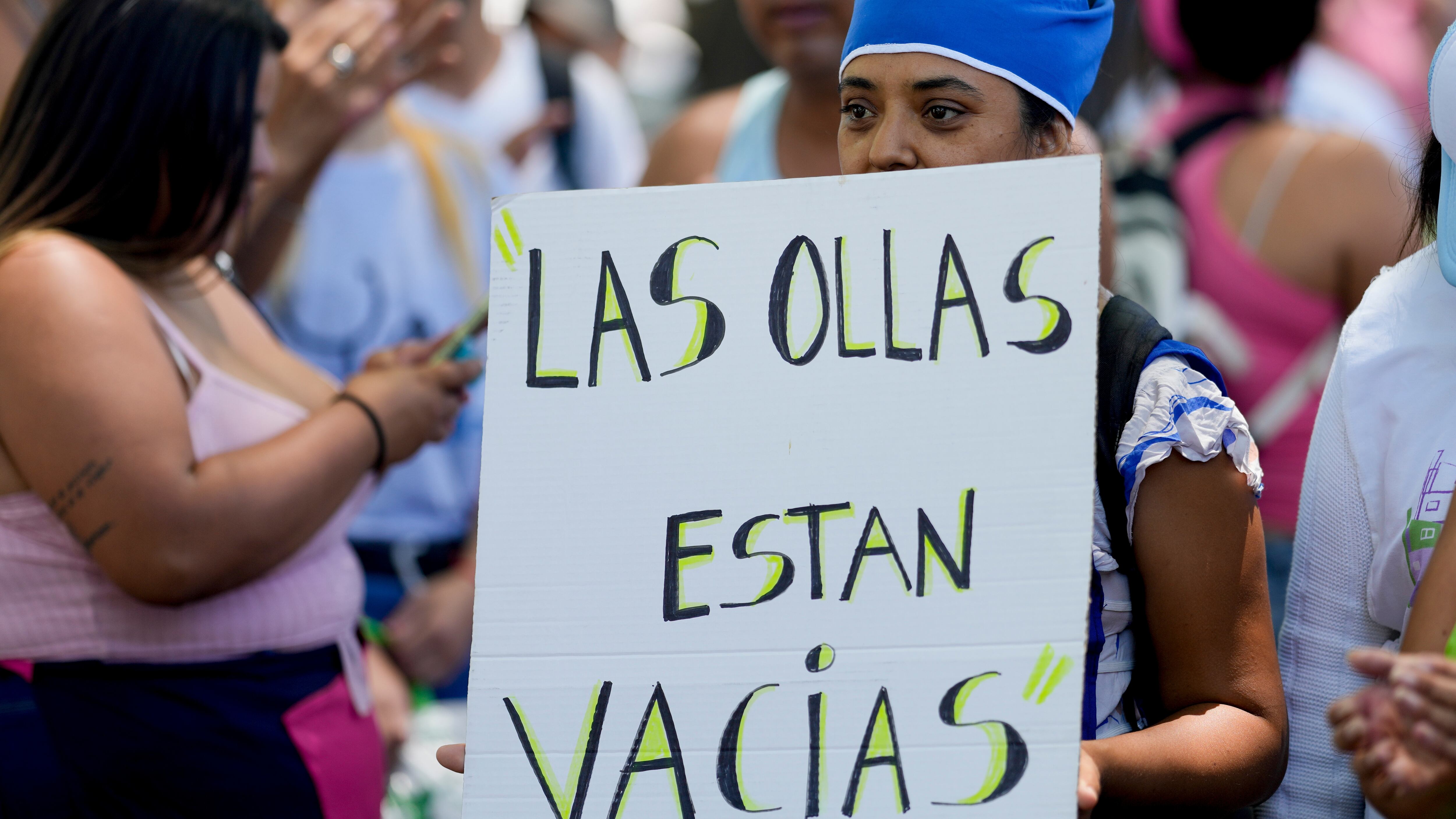 Un manifestante sostiene un cartel que dice "Las ollas están vacías" durante una manifestación contra las reformas económicas del gobierno (AP Foto/Natacha Pisarenko)