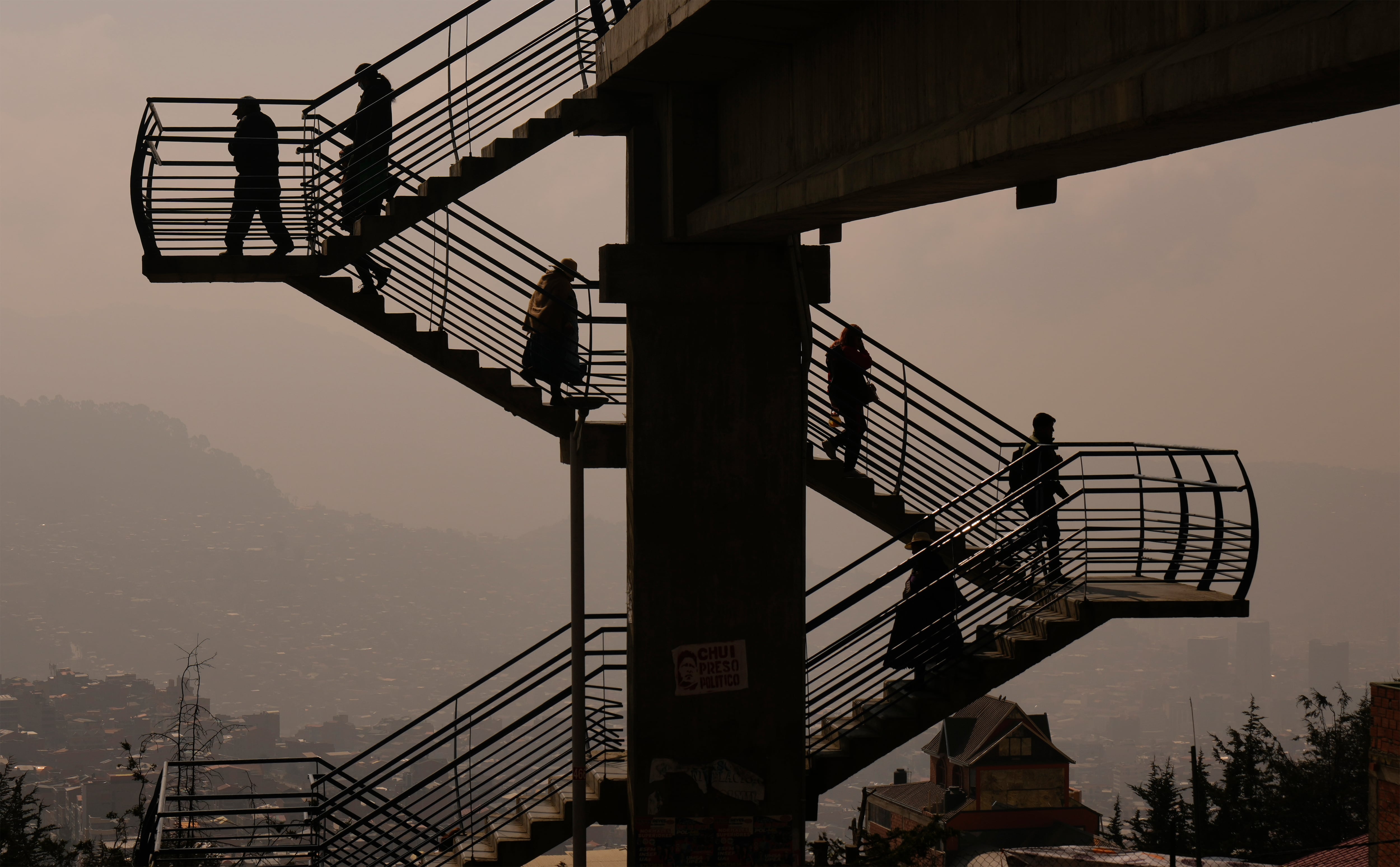 El humo de los incendios llena el aire en La Paz, Bolivia, donde los peatones usan escaleras que les permiten cruzar una carretera, el jueves 5 de septiembre de 2024. (AP Foto/Juan Karita)