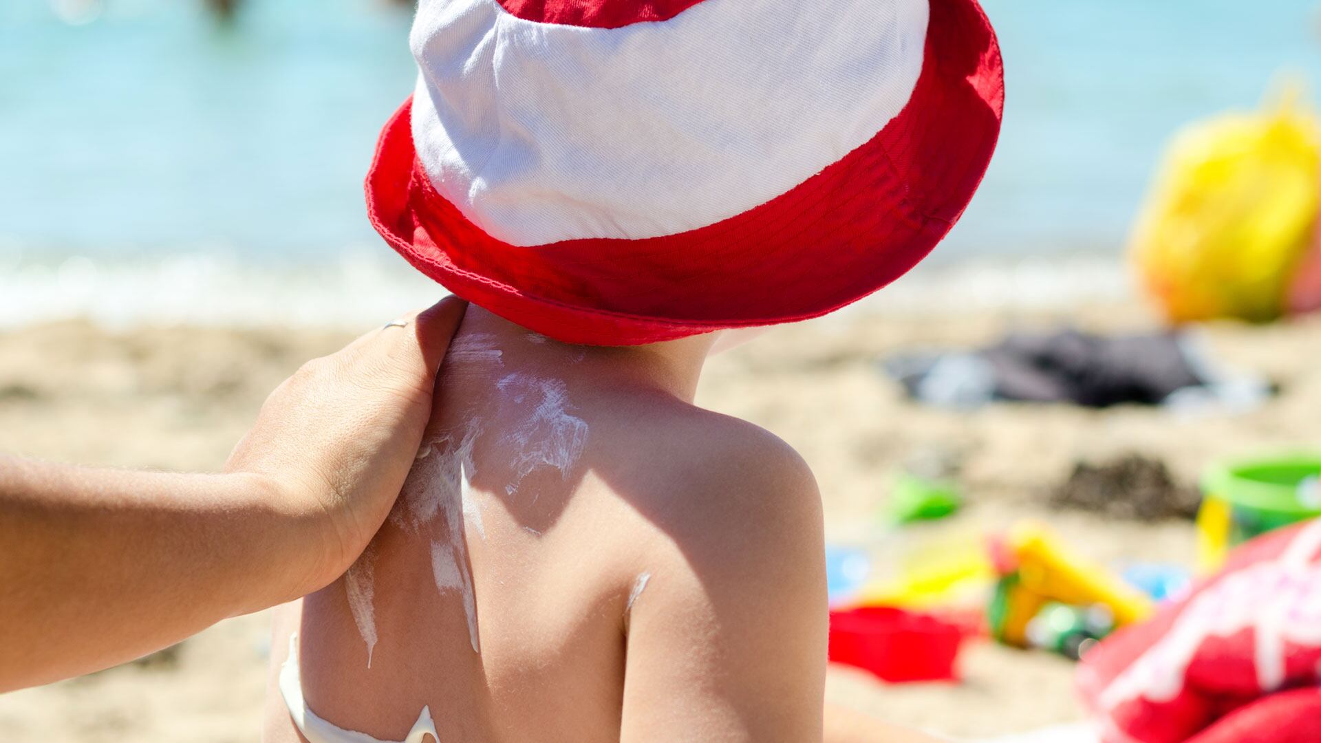 Una madre aplica protección solar a su hijo (Shutterstock)
