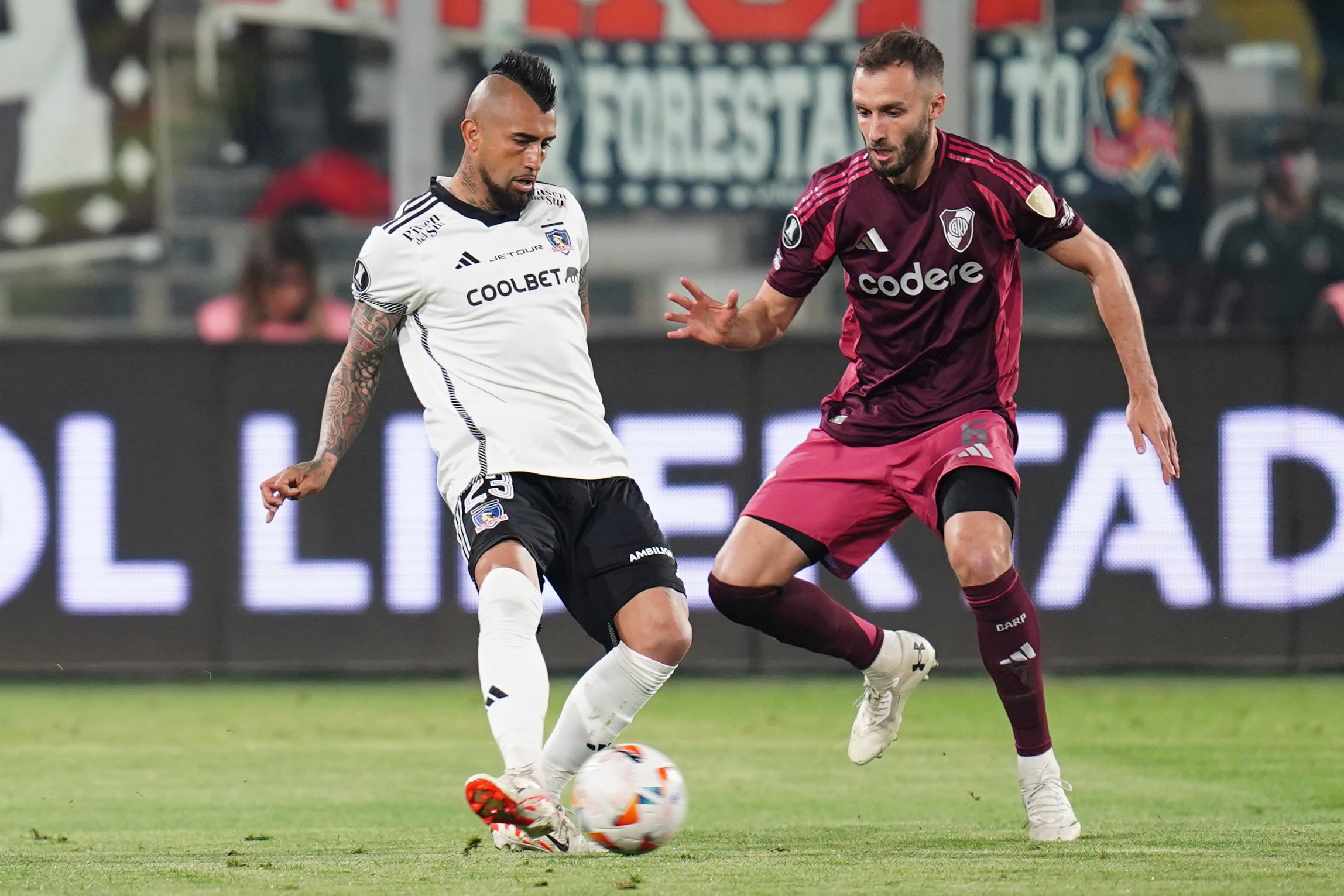 Arturo Vidal disputa una pelota con Germán Pezella en el partido de ida de los cuartos de final de la Copa Libertadores entre Colo Colo y River Plate. Véliz criticó duramente al "Rey Arturo" (AP Foto/Luis Hidalgo)