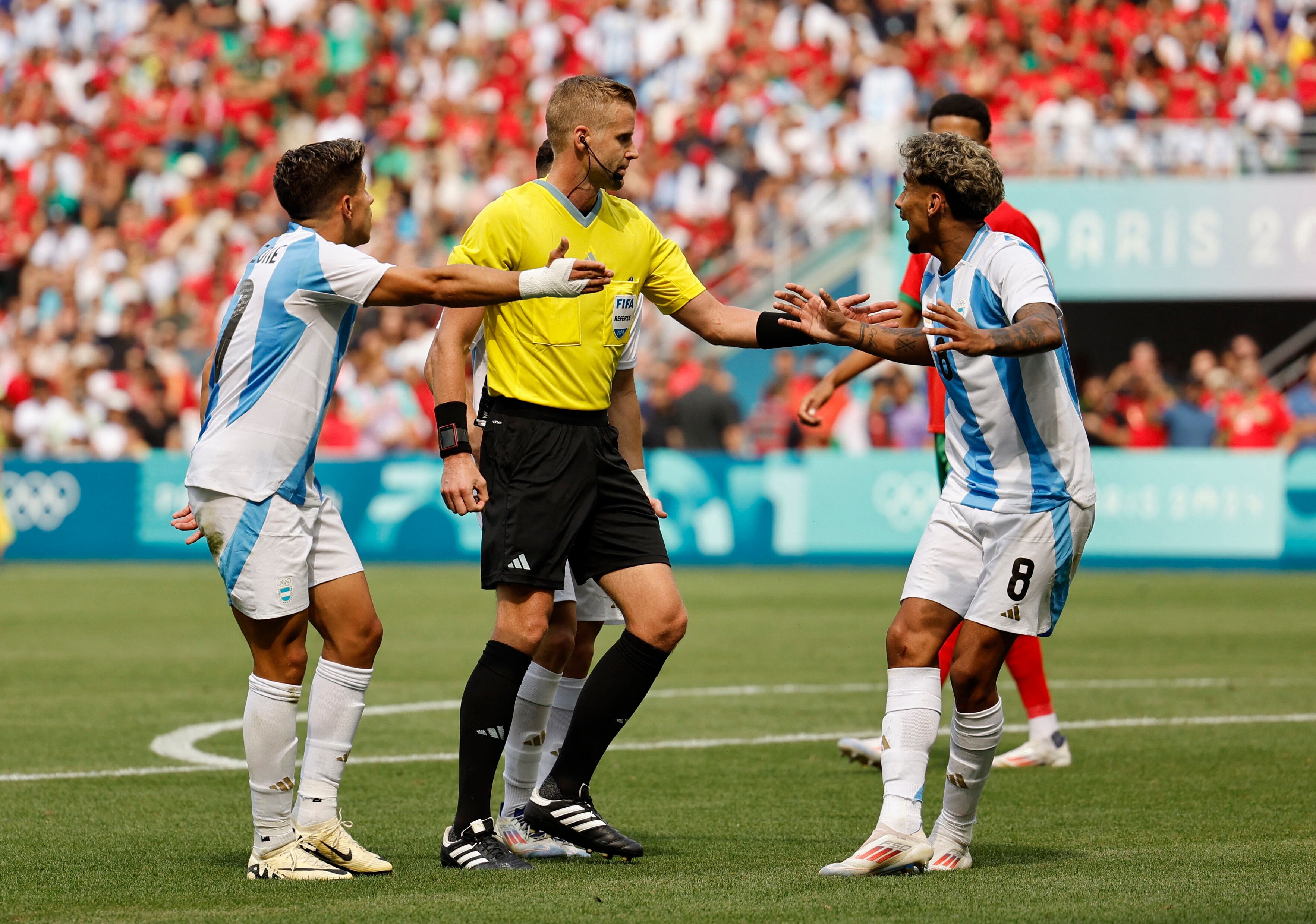 El árbitro sueco Glenn Nyberg habla con Cristian Medina en el partido Argentina-Marruecos (REUTERS/Thaier Al-Sudani)